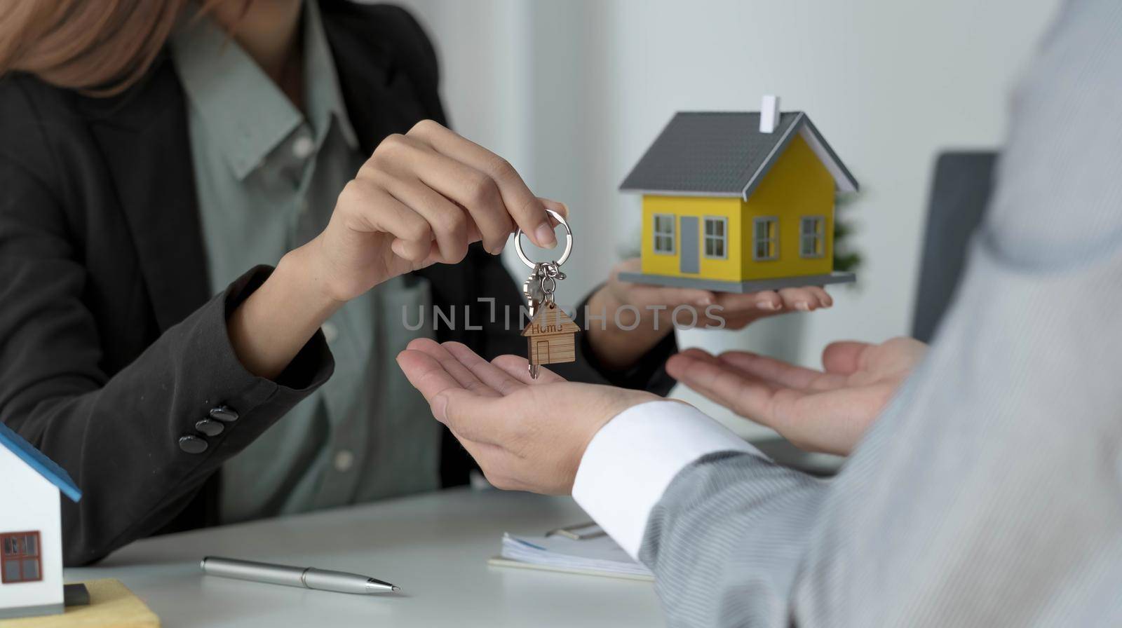 The house selling broker holds the keys and the model house is given to the customers,Real estate concept. by wichayada