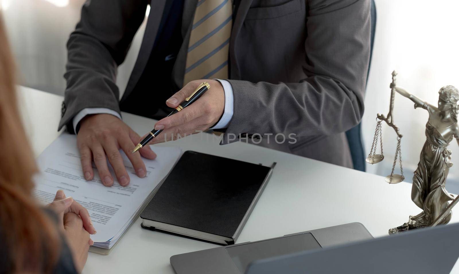 Business woman and lawyers discussing contract papers with brass scale on wooden desk in office. Law, legal services, advice, Justice concept..