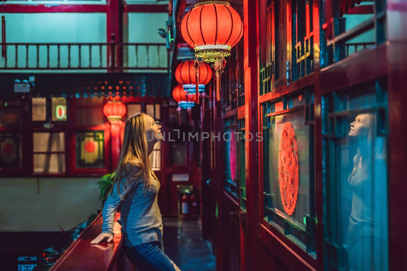 Young woman tourist looks at the Chinese traditional lanterns. Chinese New Year. Travel to China concept.