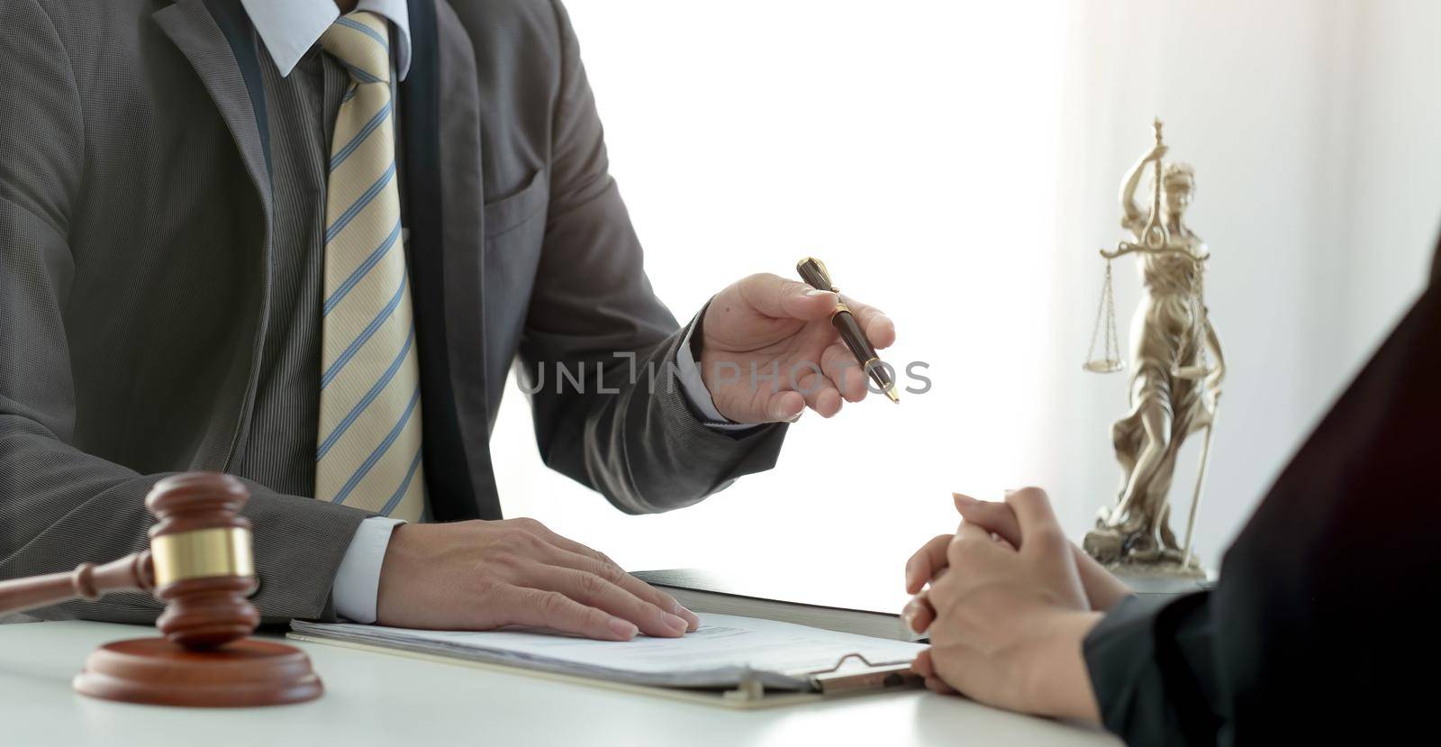 Business woman and lawyers discussing contract papers with brass scale on wooden desk in office. Law, legal services, advice, Justice concept..