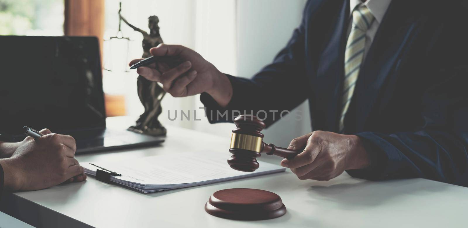 Business and lawyers discussing contract papers with brass scale on desk in office. Law, legal services, advice, justice and law concept picture with film grain effect.