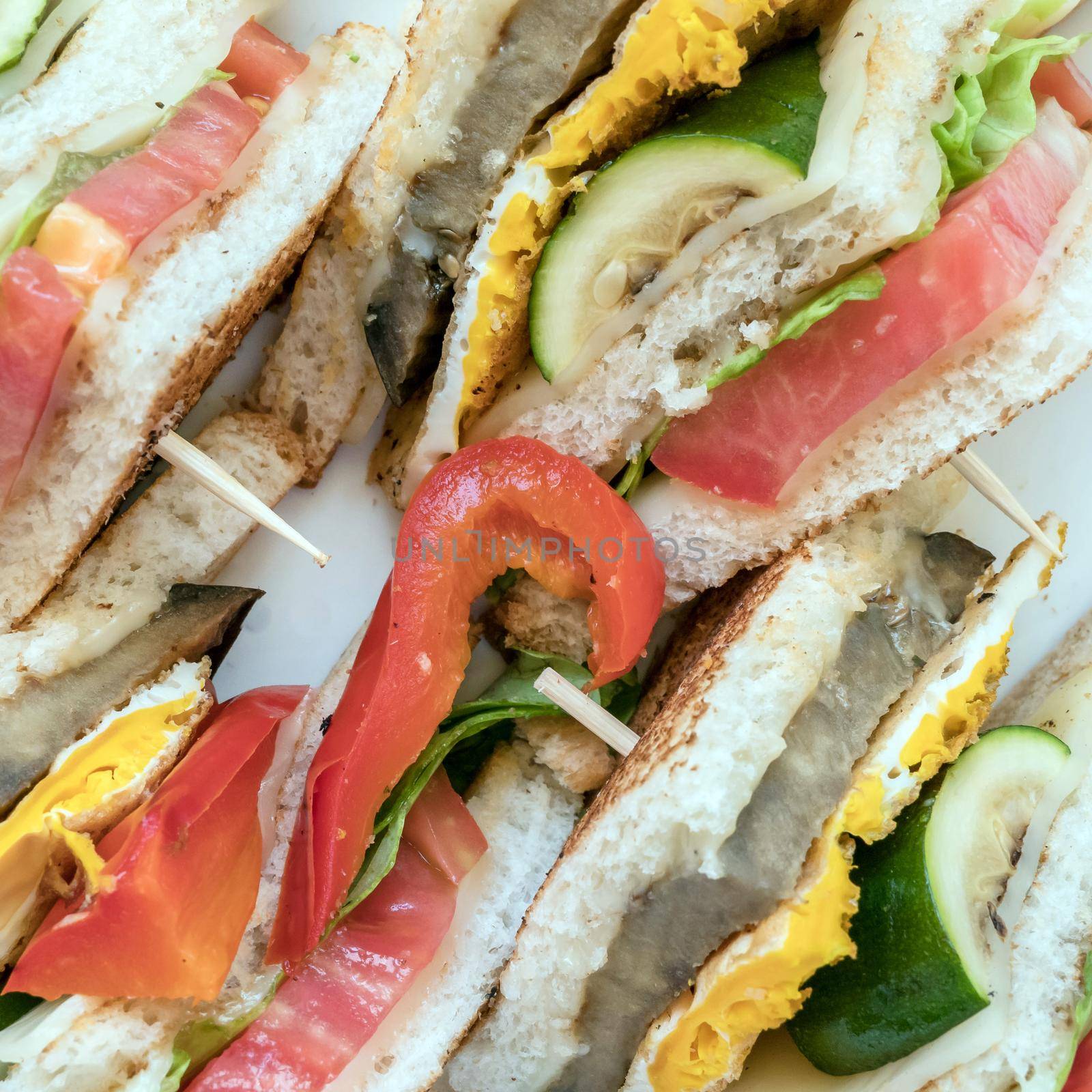 Italian tramezzini. Vegetarian sandwiches. Healthy toasts with omelette, peppers, courgettes and tomatoes for breakfast or lunch. Plant-based diet. Whole food concept. Close-up.