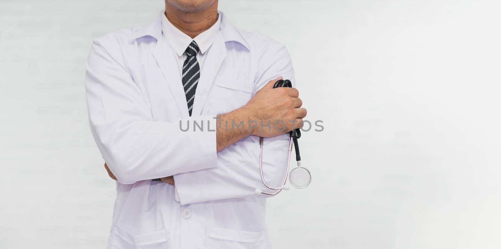 Doctor with arms crossed holding stethoscope isolated white background. Doctor standing with his arms and copy space. Health doctor hospital concept.