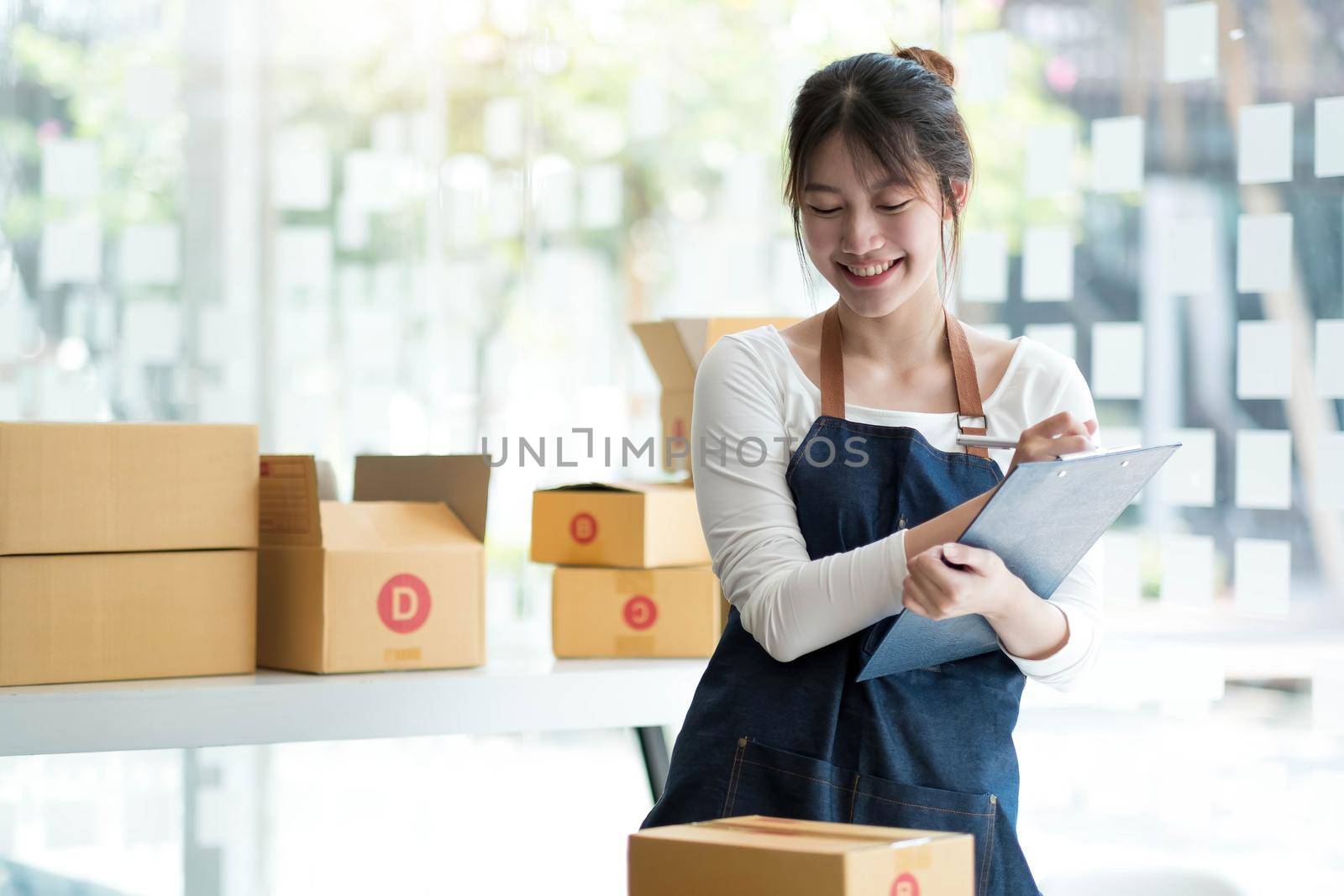 Starting small businesses SME owners female entrepreneurs Use a laptop or notebook to receive and review orders online to prepare to pack boxes, sell to customers, SME online business ideas..