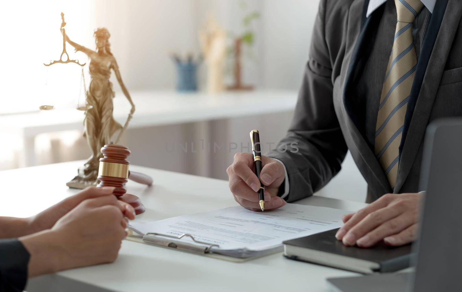 Business woman and lawyers discussing contract papers with brass scale on wooden desk in office. Law, legal services, advice, Justice concept. by wichayada