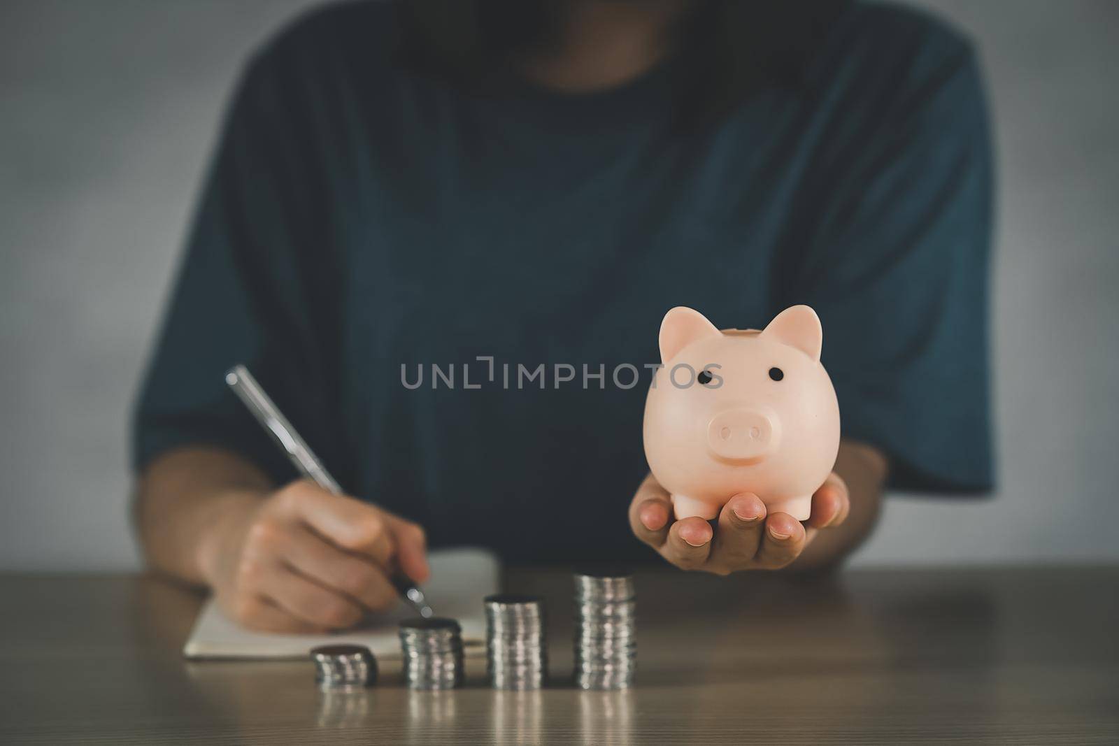 Woman holding pink piggy bank for step up growing business to profit and saving with piggy bank, Saving money for future plan and retirement fund concept.