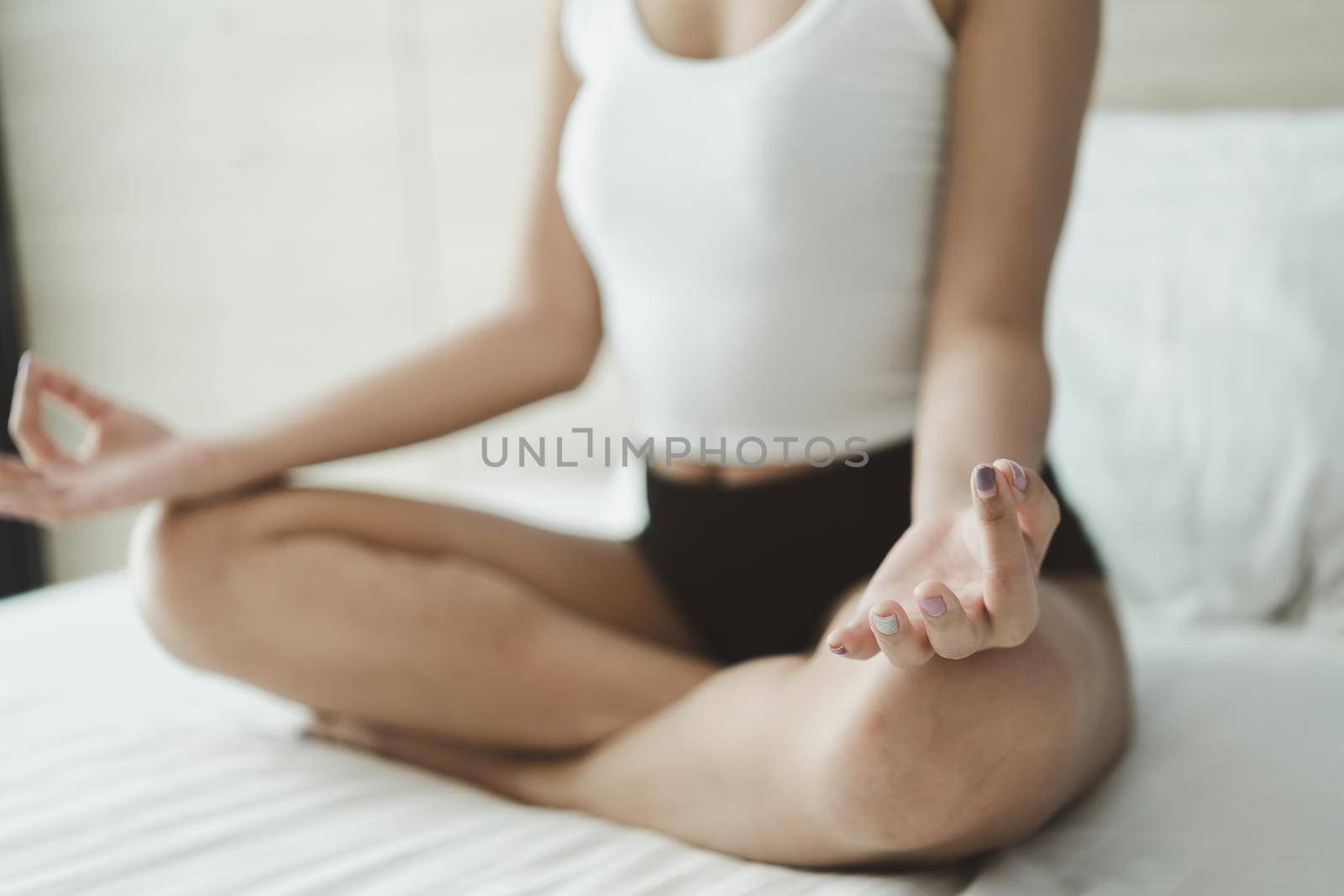 woman practicing yoga lesson, breathing, meditating, doing Ardha Padmasana exercise, Half Lotus pose with mudra gesture, working out, indoor close up. Well being, wellness concept