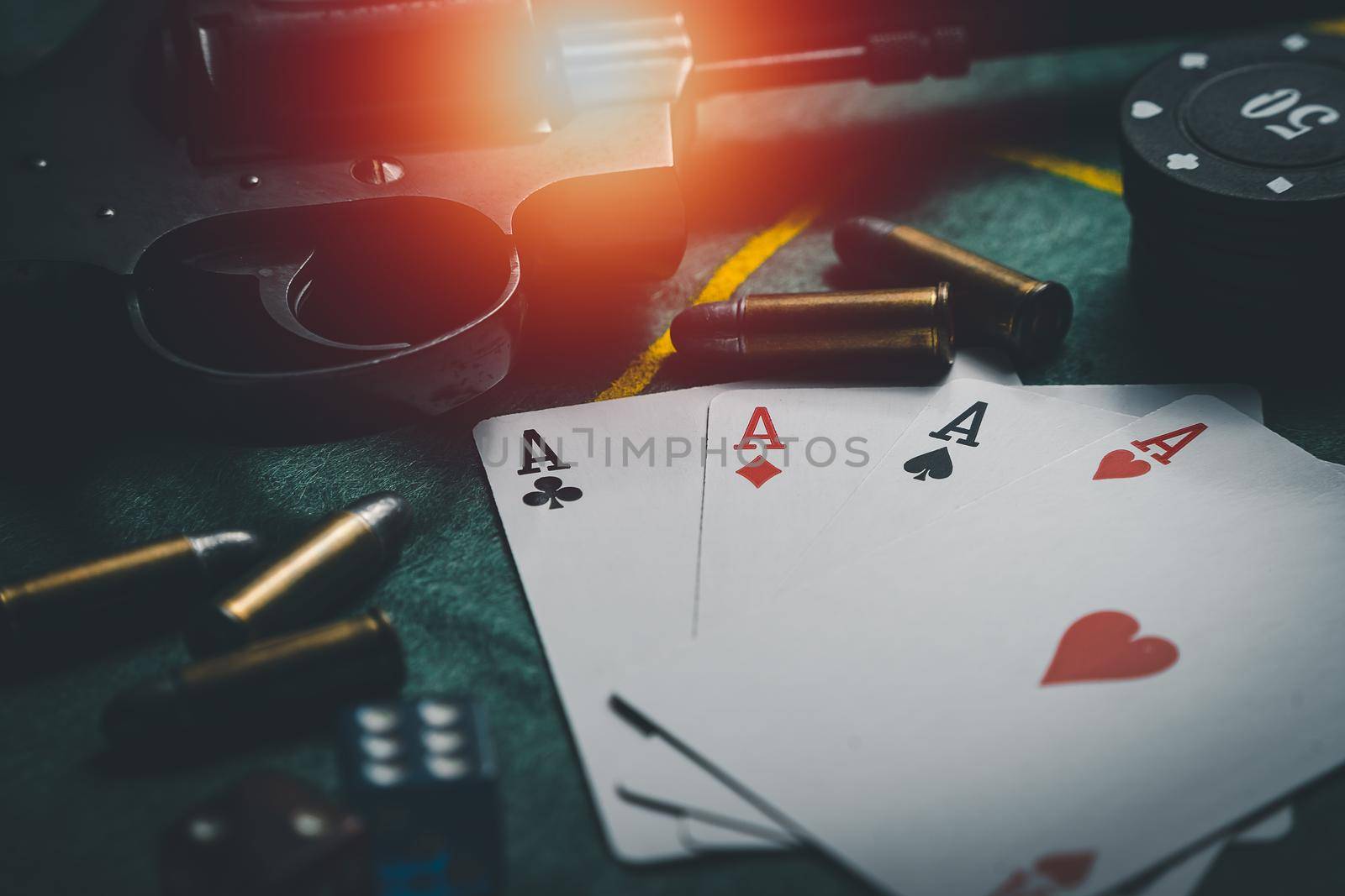 close-up playing chips, playing cards, gun and bullets. casino poker game concept. Playing cards, poker chips, and dices on green table. the view from the top by Wmpix