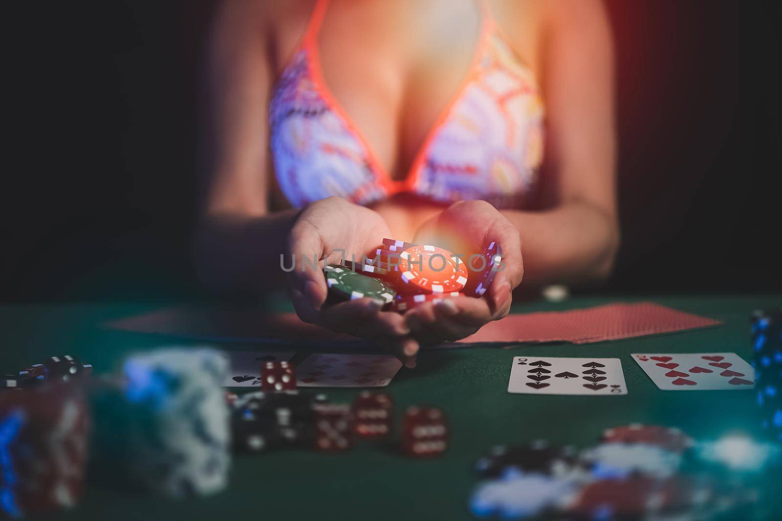 Woman wearing bikini dealer or croupier shuffles poker cards in a casino on the background of a table,asain woman holding chips. Casino, poker, poker game concept