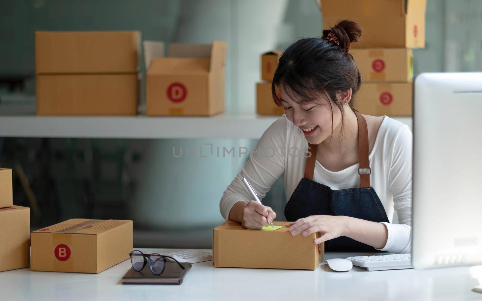 Portrait of Asian young woman SME working with a box at home the workplace.start-up small business owner, small business entrepreneur SME or freelance business online and delivery concept..