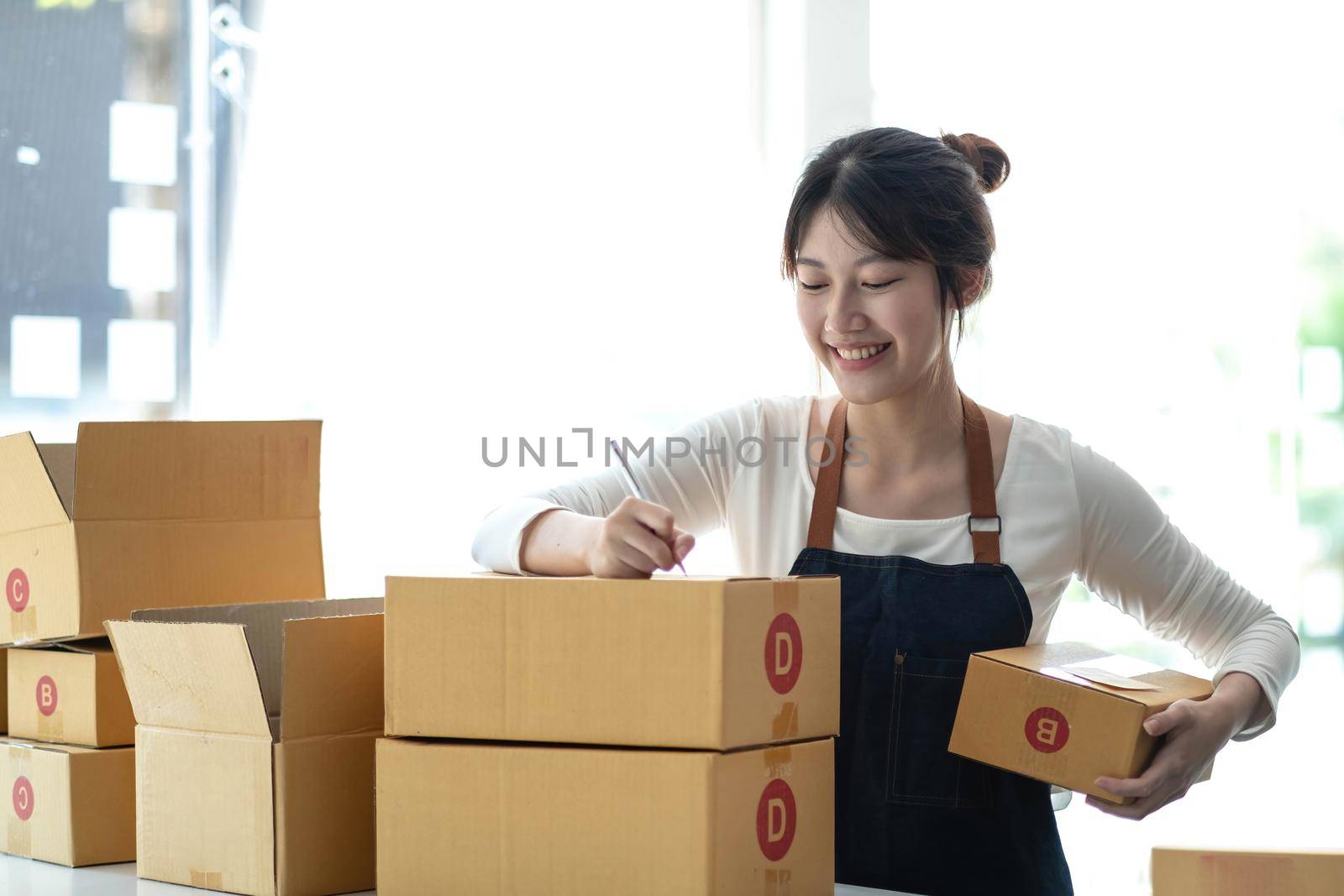 Portrait of Starting small businesses SME owners female entrepreneurs working on receipt box and check online orders to prepare to pack the boxes, sell to customers, sme business ideas online..