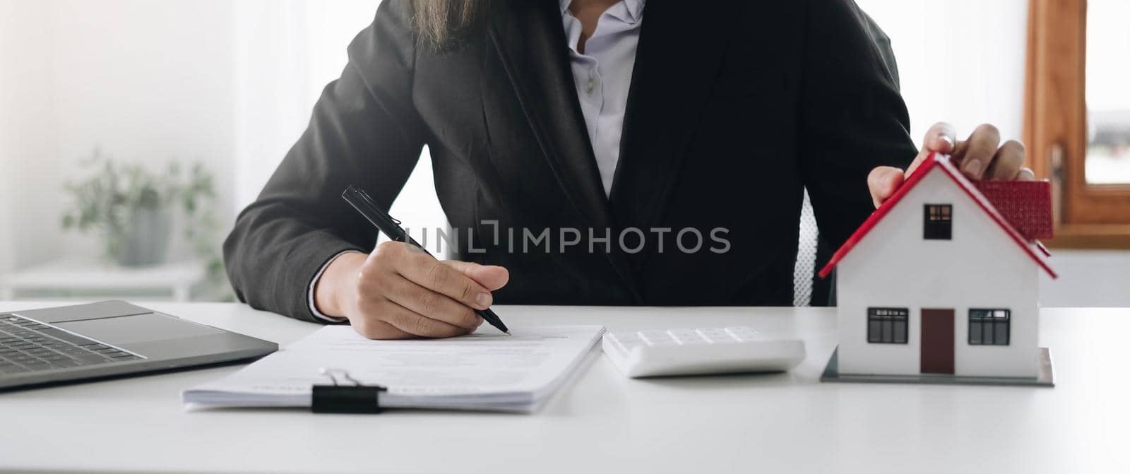 Female woman hands holding home model, small miniature white toy house. Mortgage property insurance dream moving home and real estate concept.