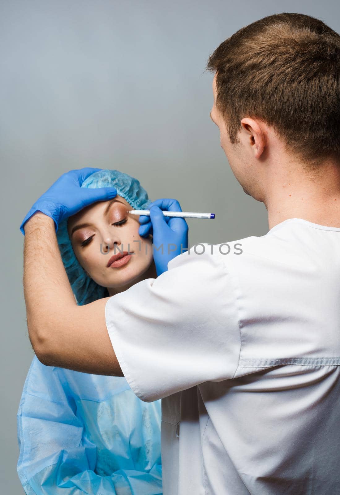 Blepharoplasty markup close-up on the face before the plastic surgery operation for modifying the eye region of the face in medical clinic. by Rabizo