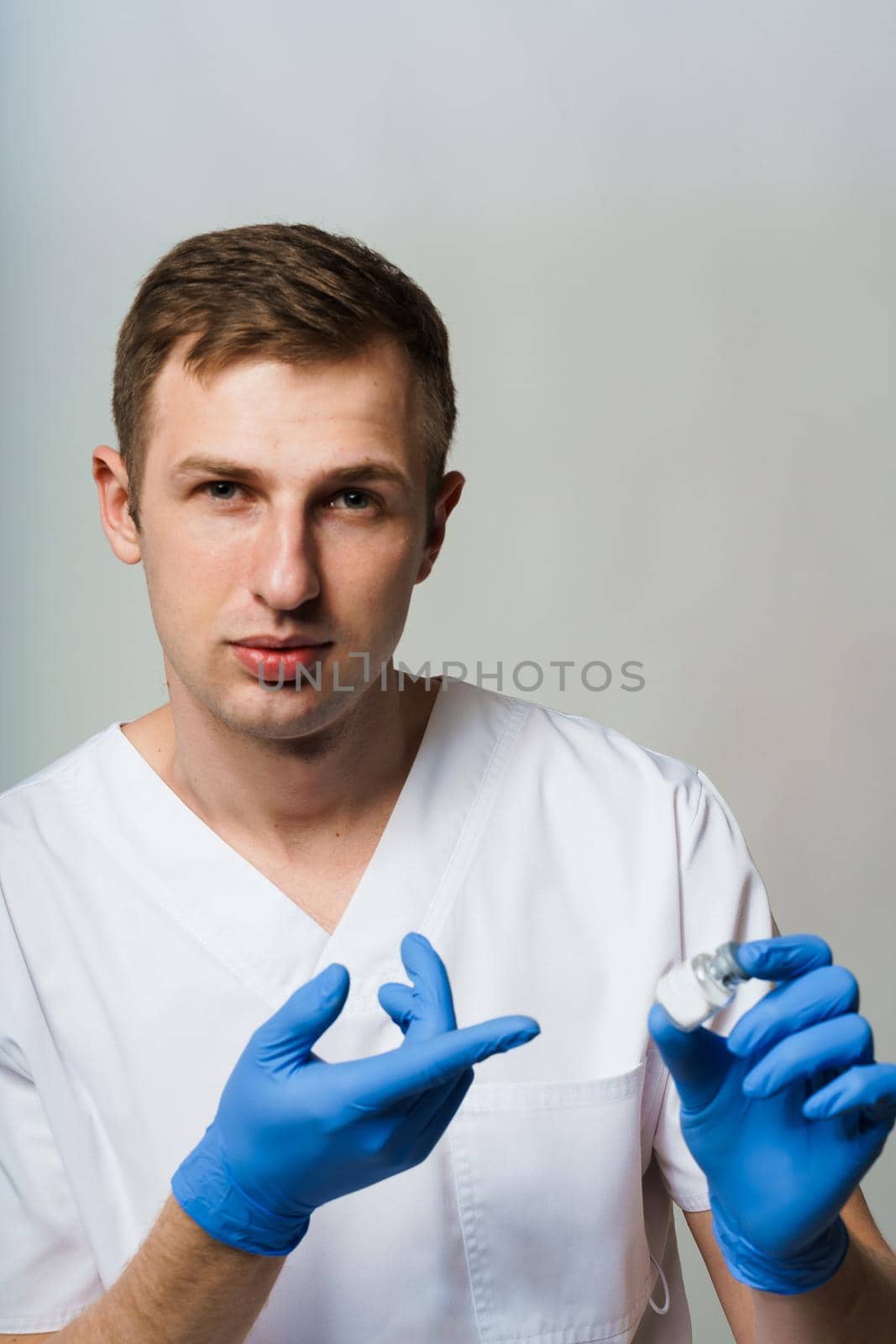 Coronavirus vaccine. Doctor holding covid-19 vaccine in his hands. by Rabizo