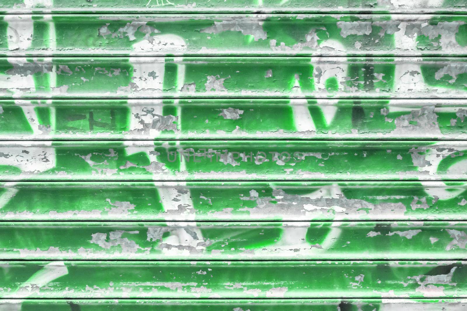 Green metal shutter with peeling paint. Ideal use for background / wallpaper.