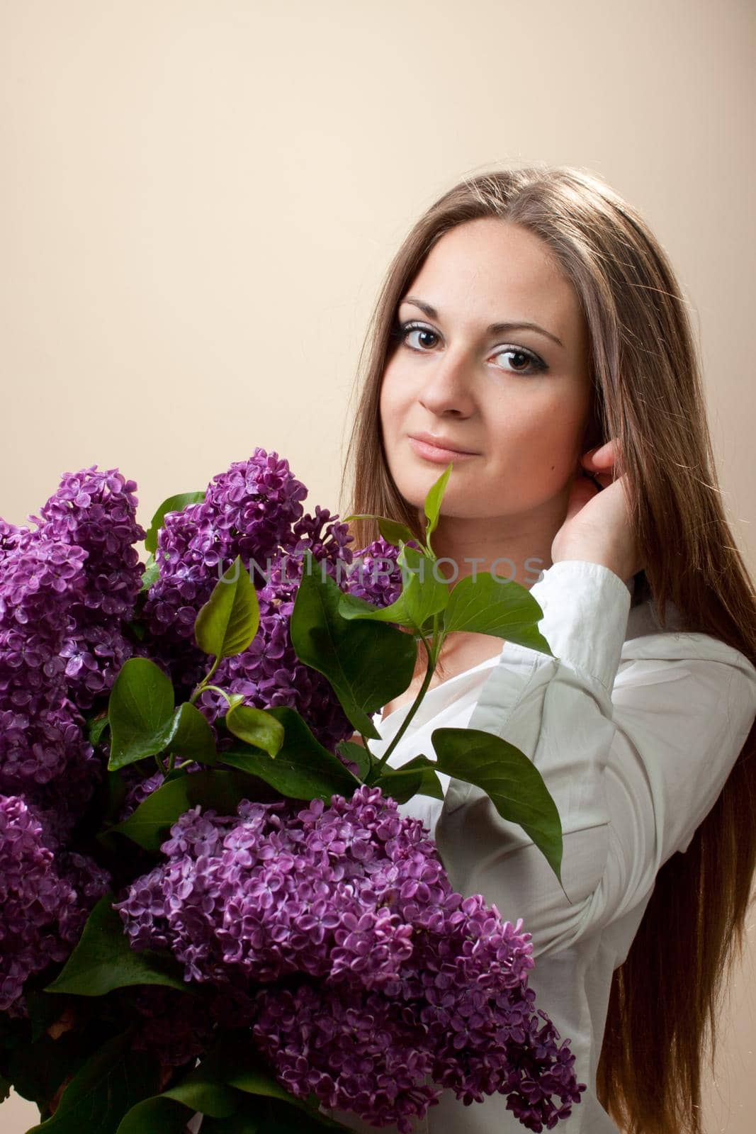 Beautiful young girl with a bouquet of lilac. Spring flowers concept.