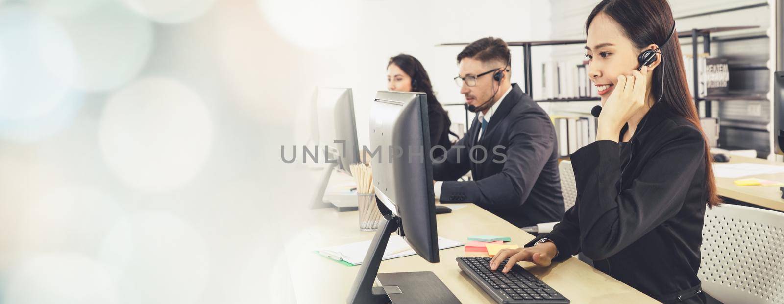 Business people wearing headset working in office to support remote customer or colleague. Call center, telemarketing, customer support agent provide service in broaden view .