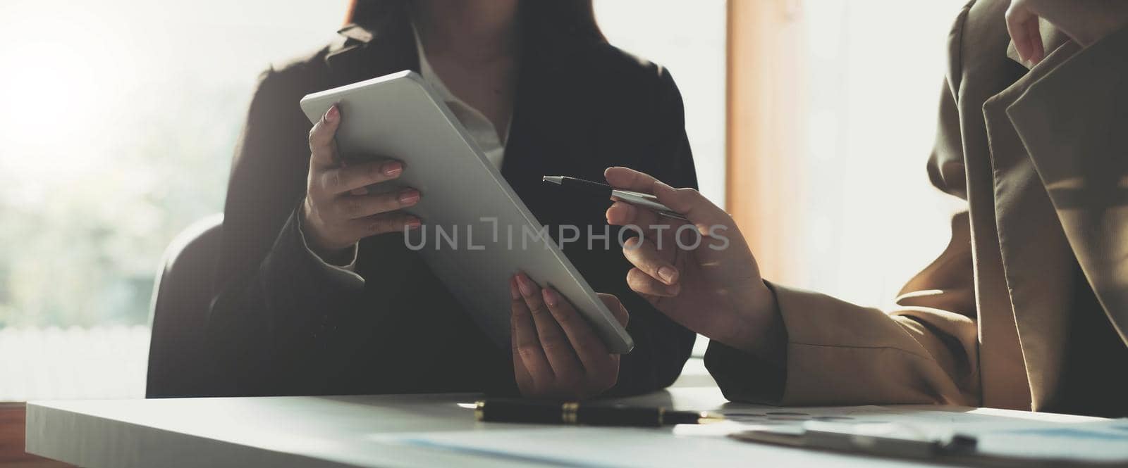 Close-up of two female hands hold pen and point document in touchpad.