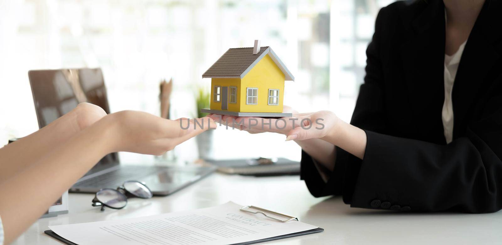Real estate company to buy houses and land are delivering keys and houses to customers after agreeing to make a home purchase agreement and make a loan agreement. Discussion with a real estate agent.