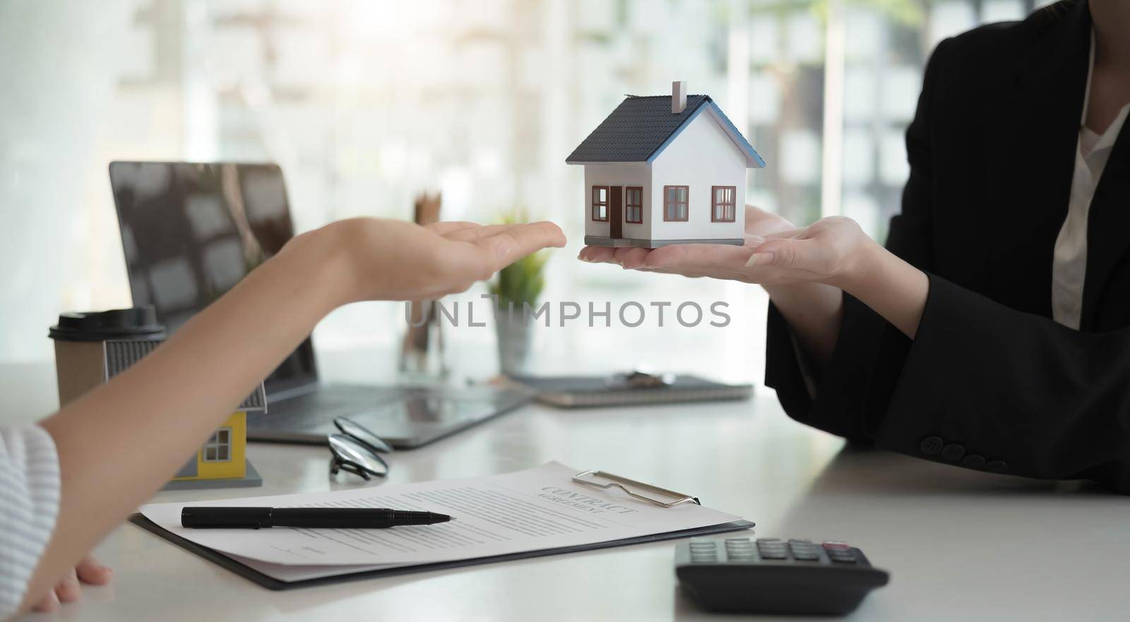 Sale representative offer house purchase contract to buy a house or apartment or discussing about loans and interest rates by wichayada