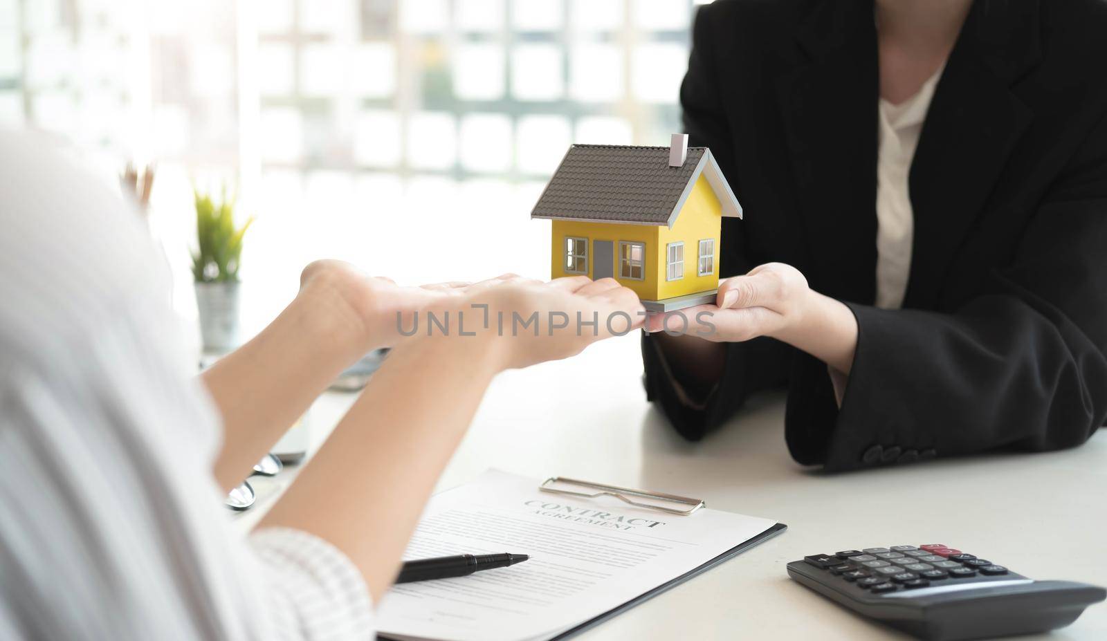 Sale representative offer house purchase contract to buy a house or apartment or discussing about loans and interest rates.