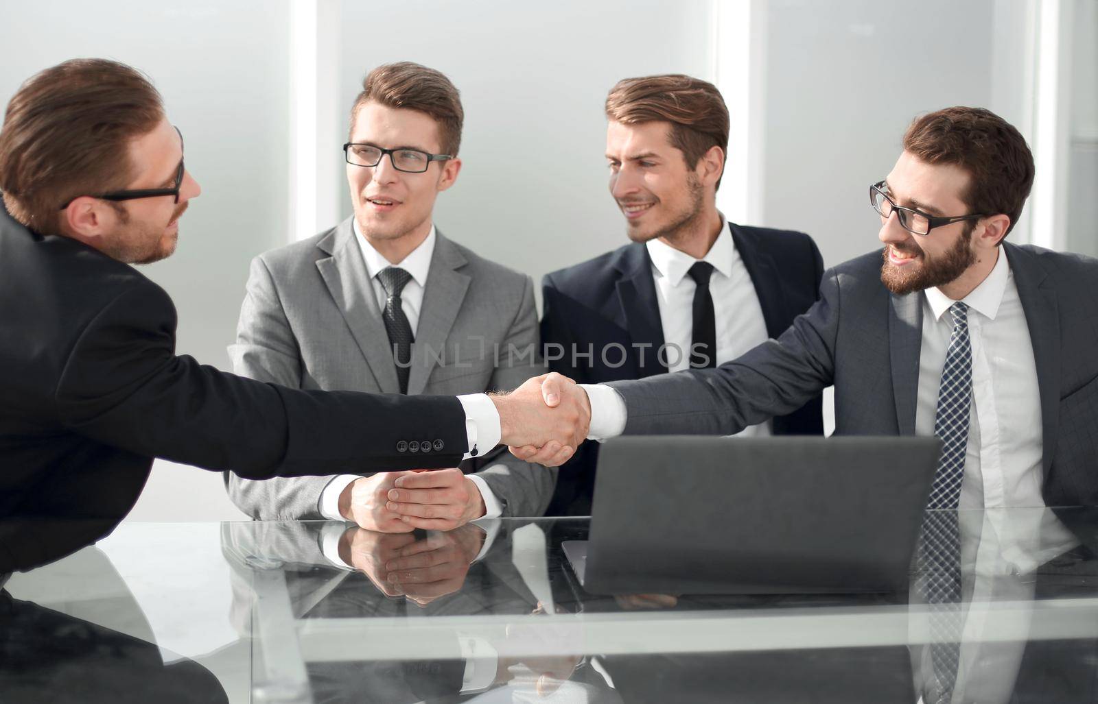 employees greet each other with a handshake by asdf