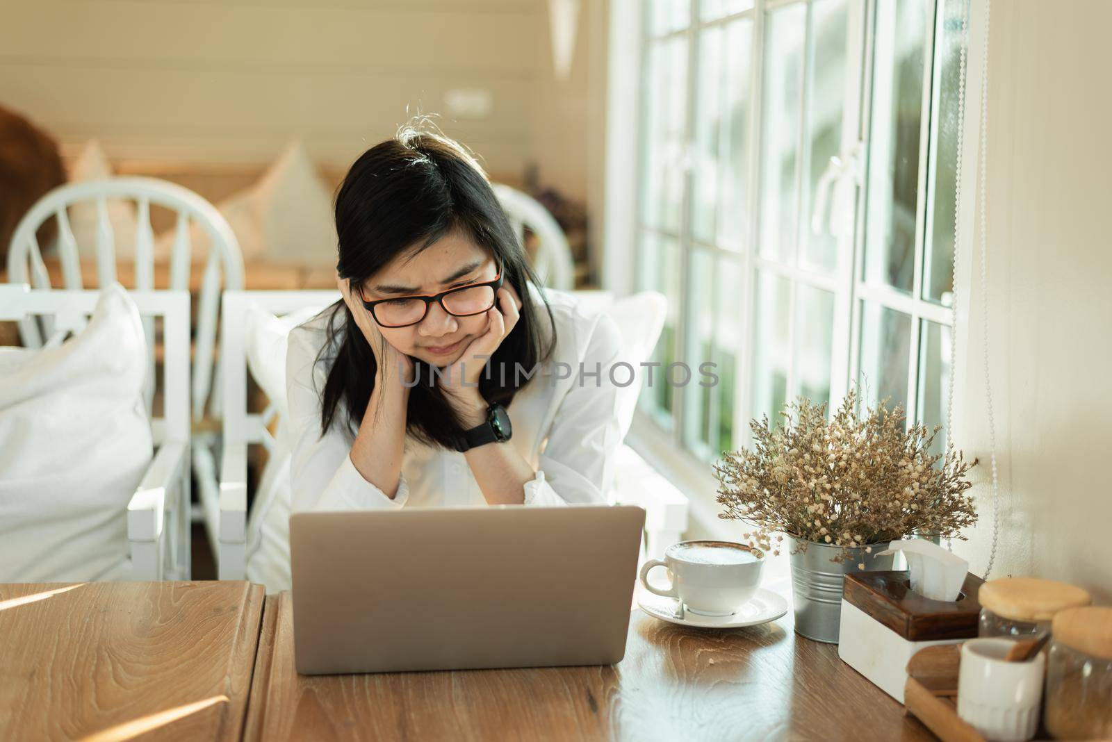 Business asian woman feel tired and holding head serious and working with laptop. Depression asian woman working hard. by Wmpix