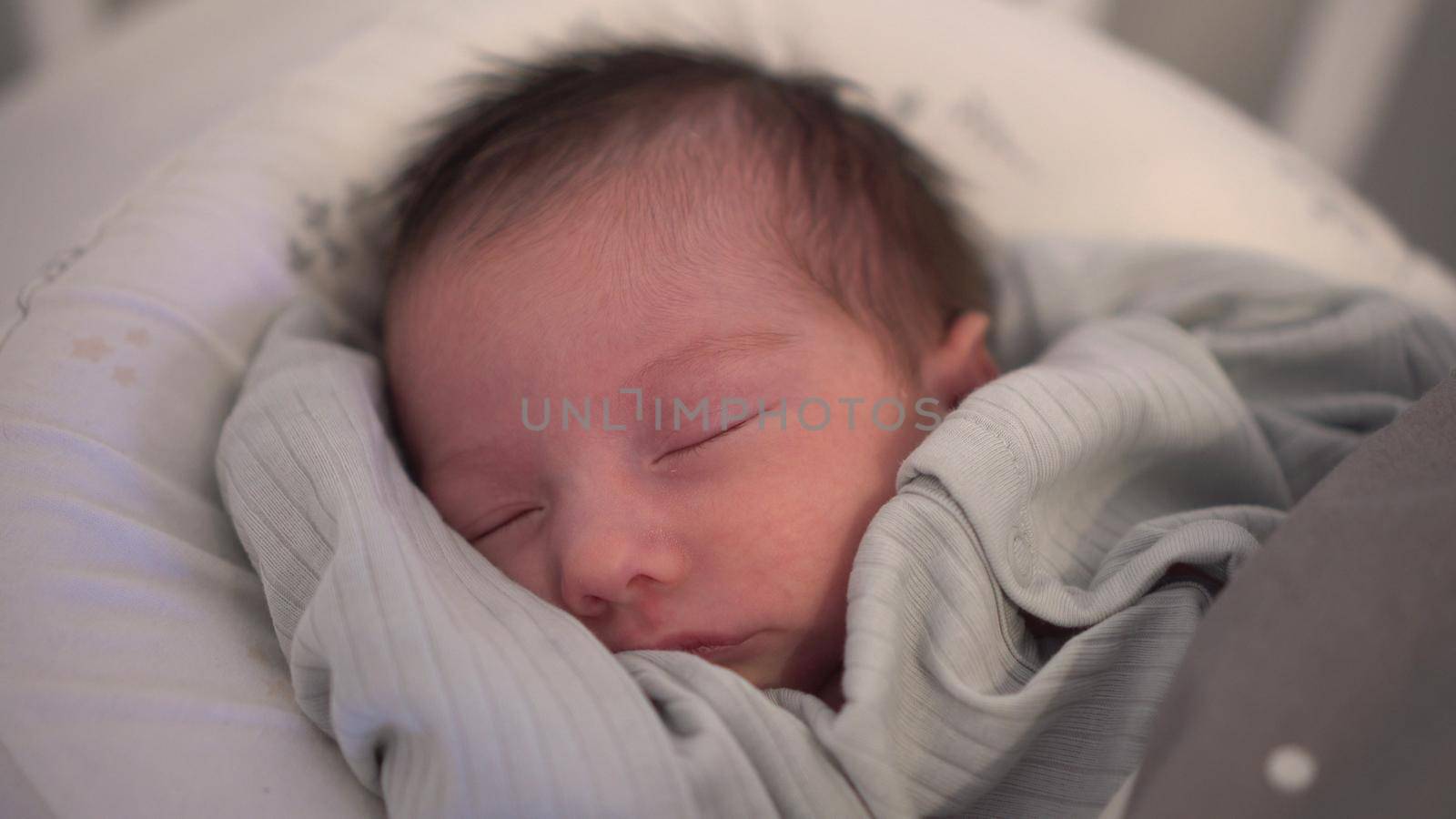 The child sleeps peacefully in a cocoon. Newborn baby sleeping face close-up. 4k