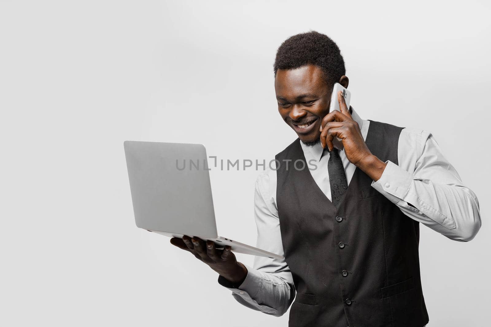 Online dating agency. Black man with laptop and phone speaks with women all over the world. Business man finding his love in internet by Rabizo