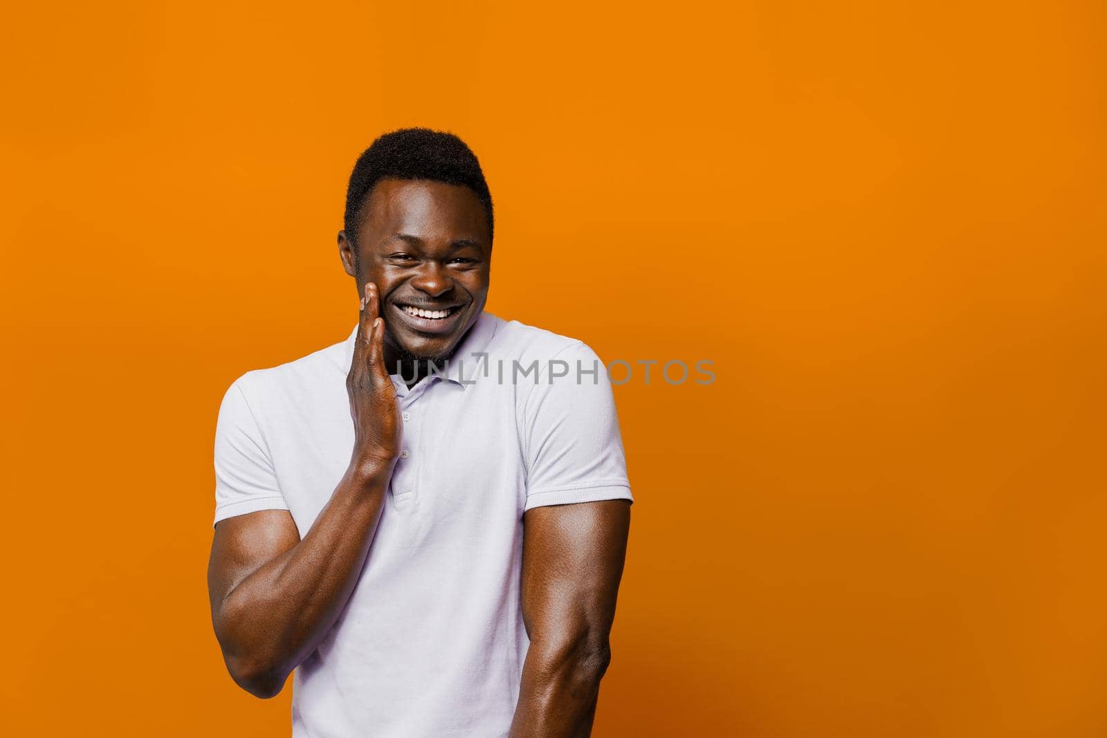 Funny black man jokes and smiles on orange background. Big discount for customers. Smiley people lifestyle. Advertise for online delivery services