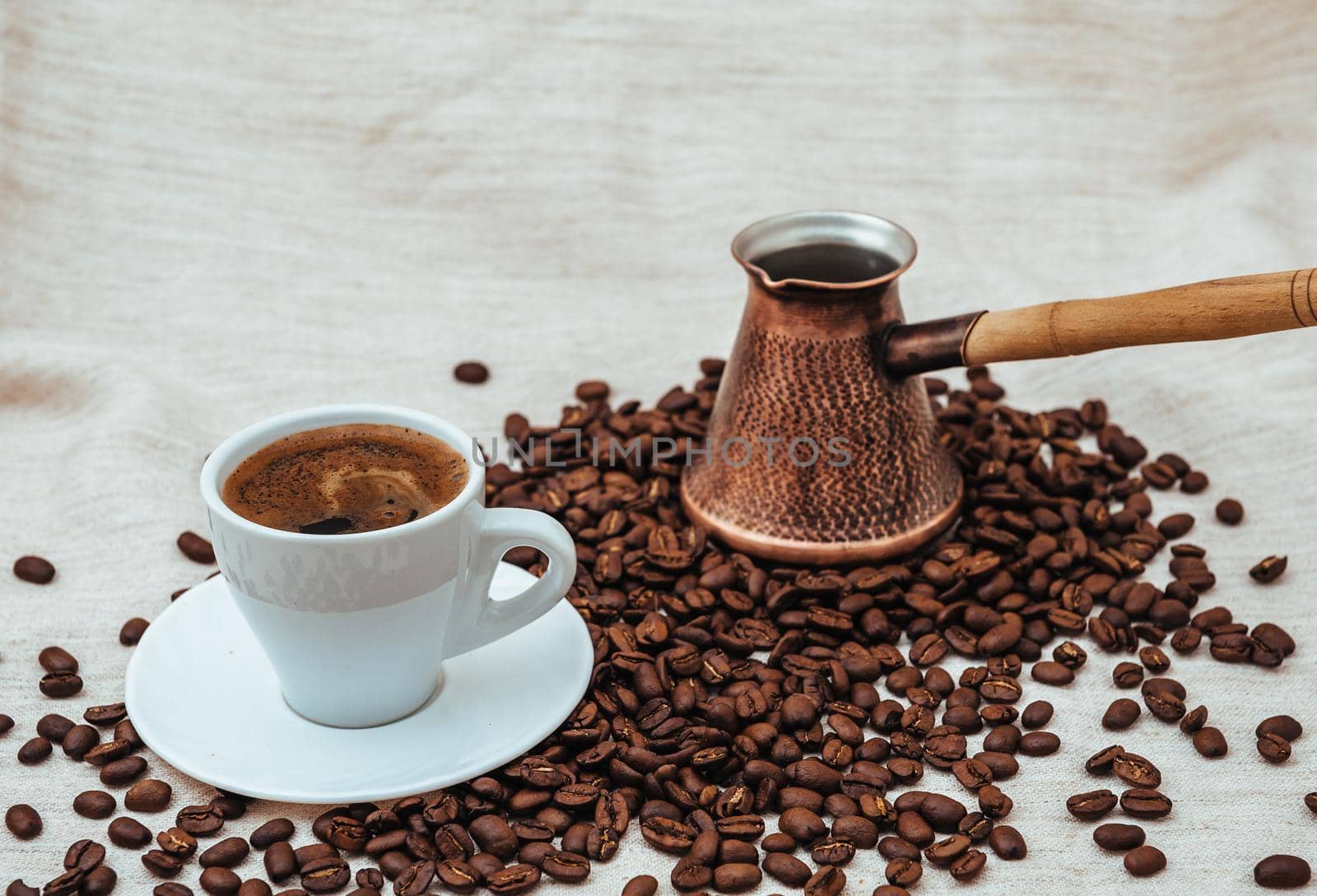 Coffee turk and cup of coffee on burlap background. coffee beans isolated on white background. roasted coffee beans