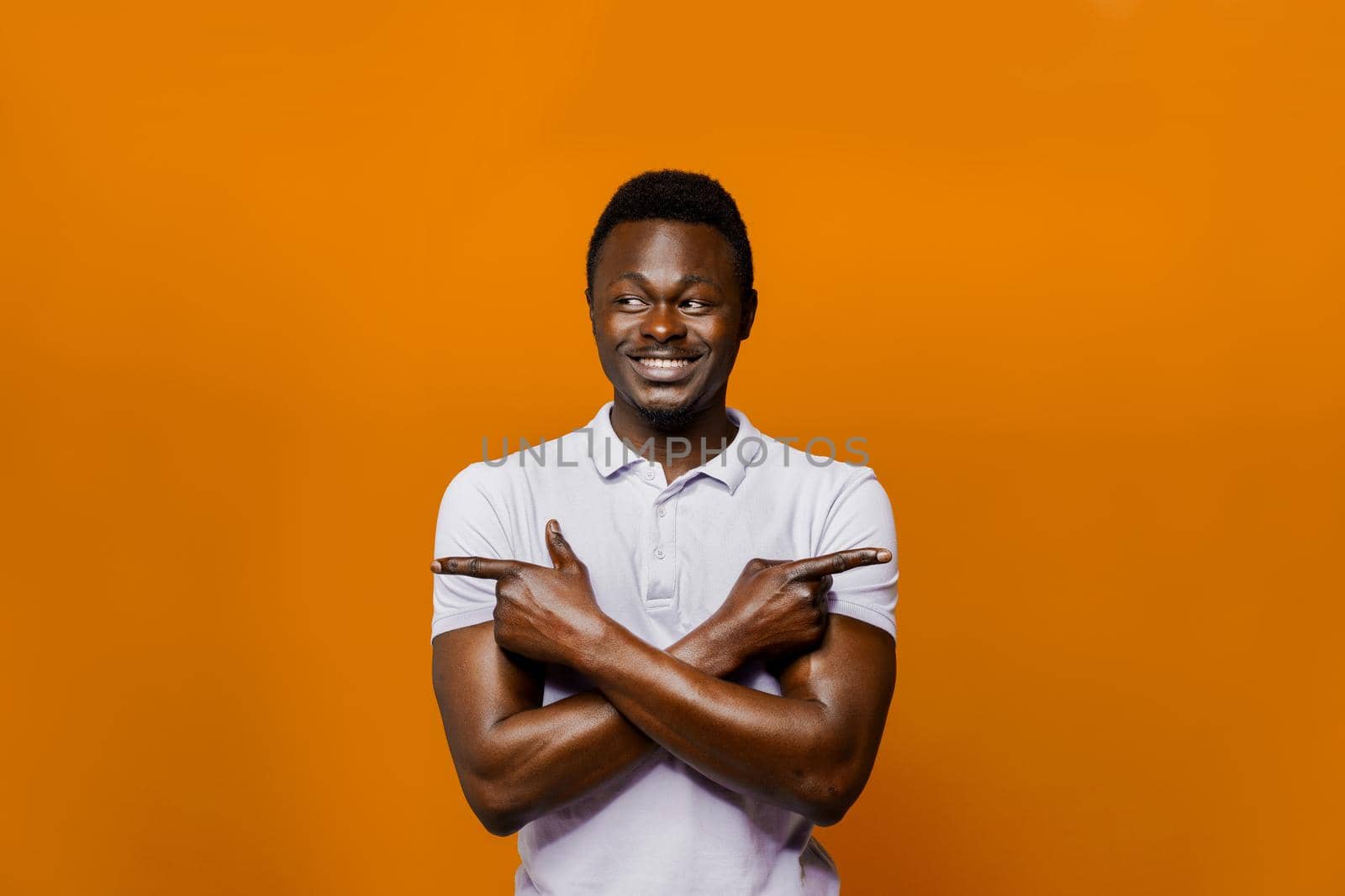 Cheerful black man points left and right side. Choosing between 2 items. Select a product. African man proposes to choose an one item from two.