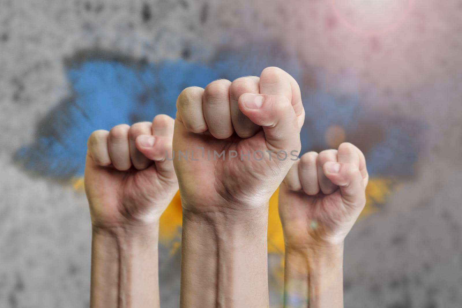 Support for Ukraine and solidarity. Help to the Ukrainian people in wartime. Fists as a symbol of support against the background of the Ukrainian flag. The concept of confrontation and struggle by SERSOL