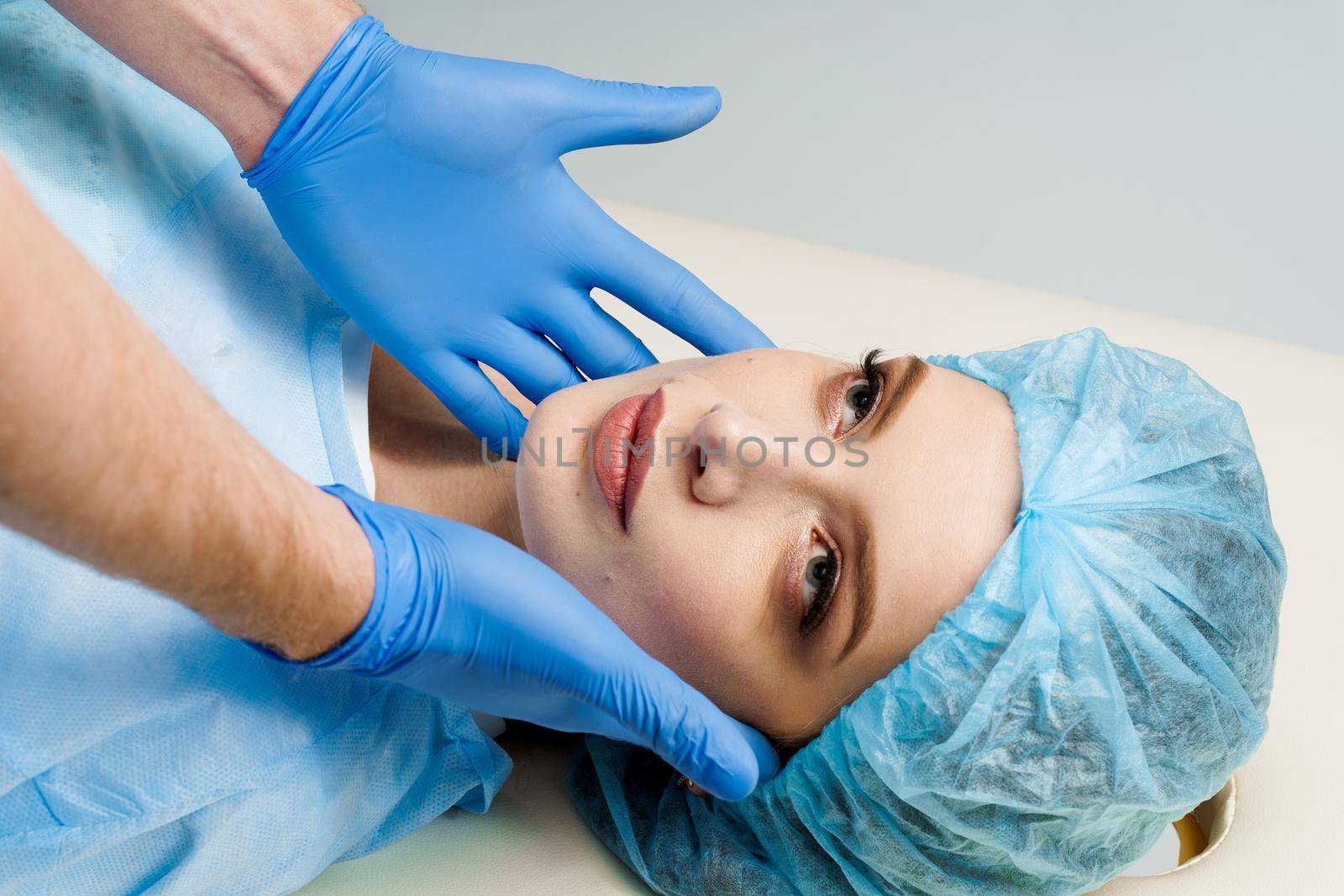 Consultation with plastic surgeon on white background. Cosmetic rejuvenating facial treatment by Rabizo