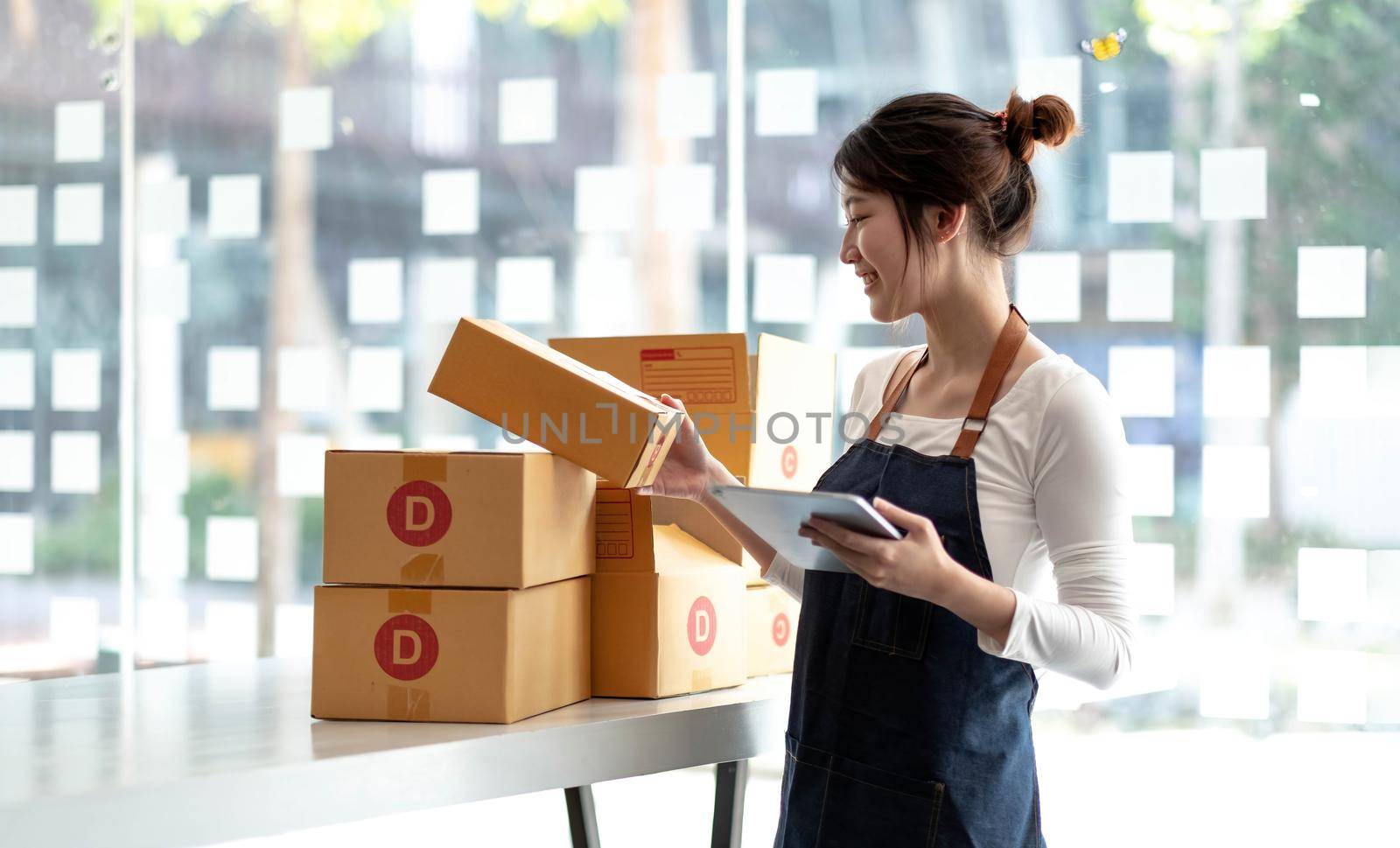 Portrait of Starting small businesses SME owners female entrepreneurs working on receipt box and check online orders to prepare to pack the boxes, sell to customers, sme business ideas online..