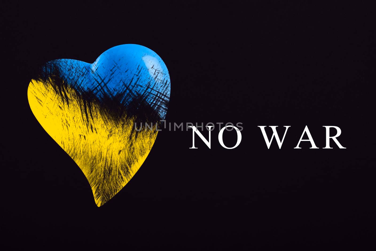 No war in Ukraine. Save Ukraine. The heart is painted in the colors of the Ukrainian flag - blue and yellow. No war text, poster on black background.