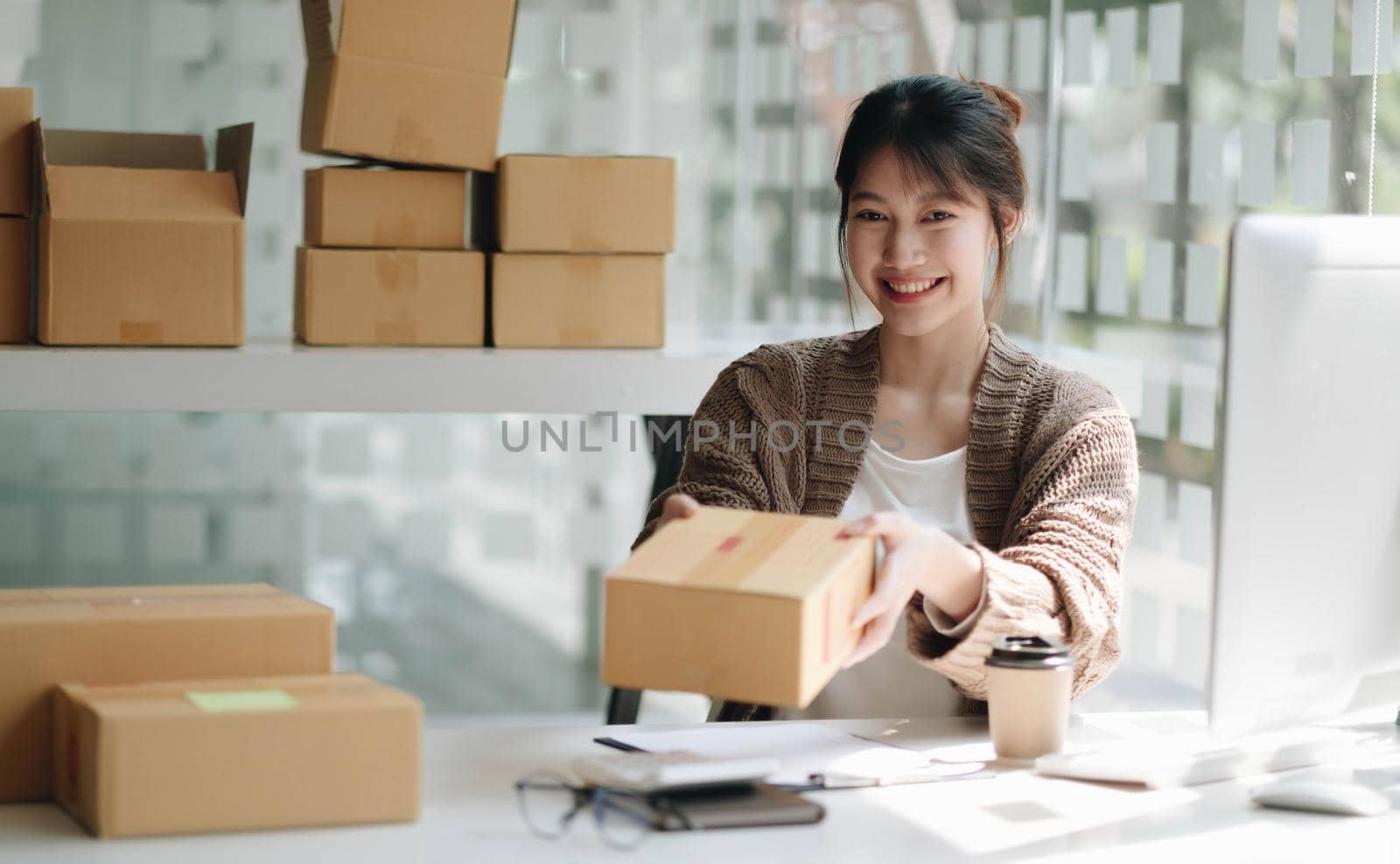 Starting Small business entrepreneur SME freelance,Portrait young woman working at home office, BOX,smartphone,laptop, online, marketing, packaging, delivery, SME, e-commerce concept..