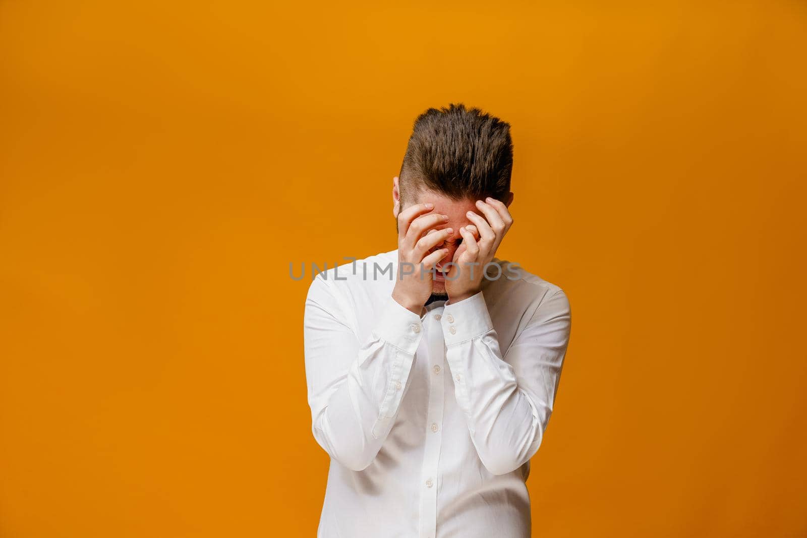 Funny handsome man fools around. Making crazy emotions. Caucasian man wears white shirt and butterfly. On-line work at home quarantine concept