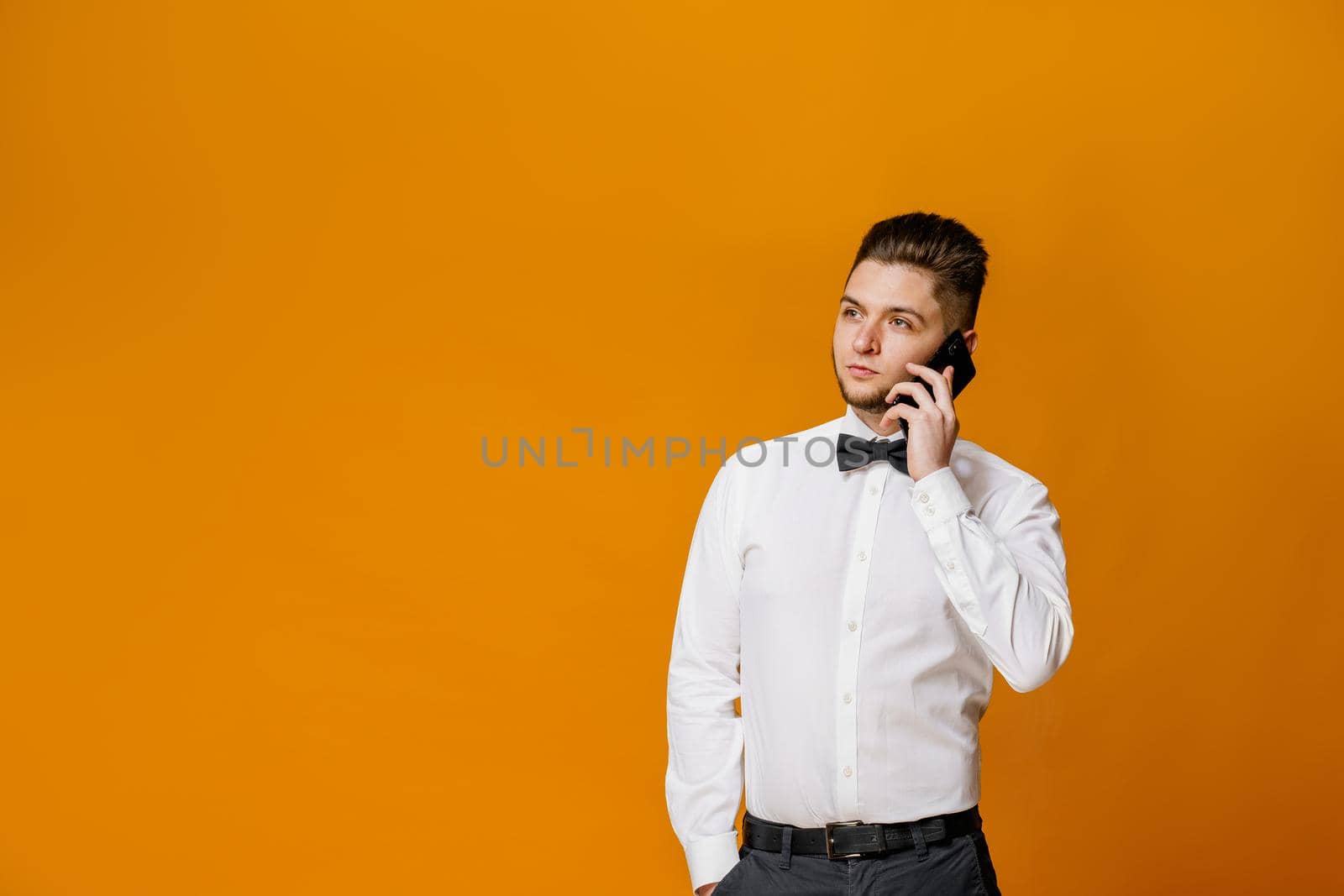 Attractive handsome man calls to safety food delivery. How to make on-line order in restaurant for delivery. On-line work at home quarantine concept