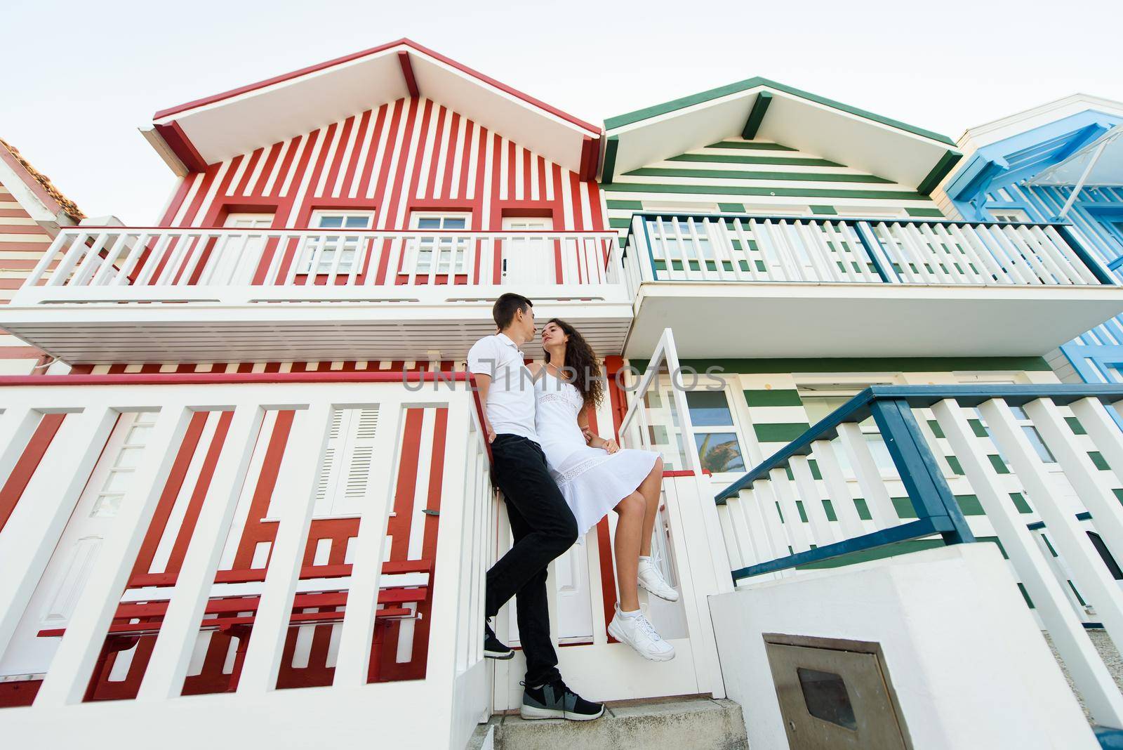 Love story of couple have fun and smiles and looks each others in Aveiro, Portugal near colourful and peaceful houses. Lifestyle