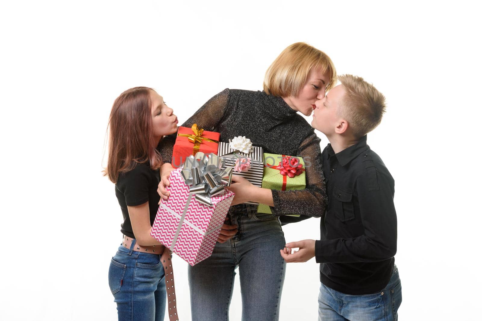 Children congratulated mom on her birthday and gave gifts, mom kisses her son as a token of gratitude