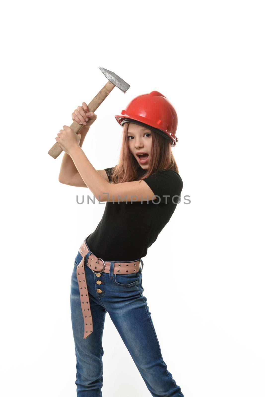 A girl in a hard hat hits herself on the head with a hammer, surprise on her face