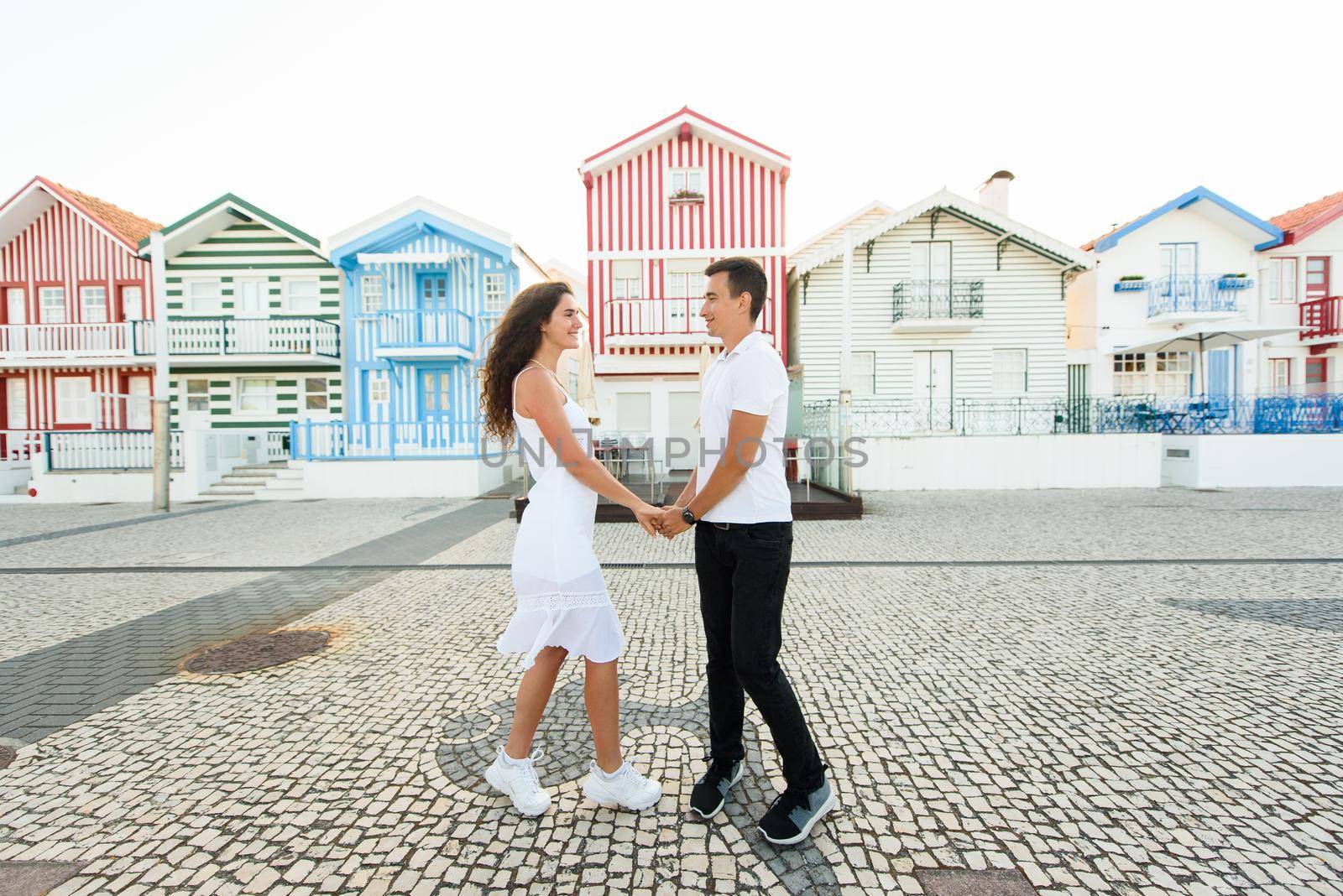 Love story of couple have dating and looks each others in Aveiro, Portugal near colourful and peaceful houses. Lifestyle. Having fun, laughs, smiles by Rabizo