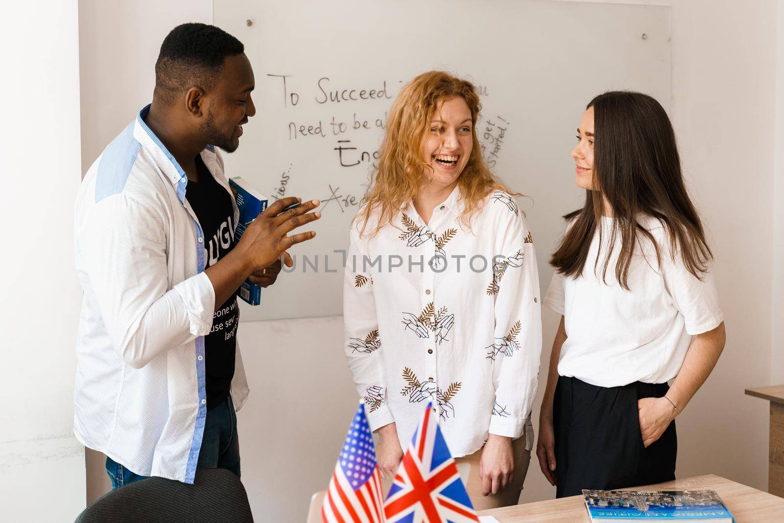 Multiethnic students and teacher study foreign languages together in class. Studing with laptop. Black handsome student study with white people together.