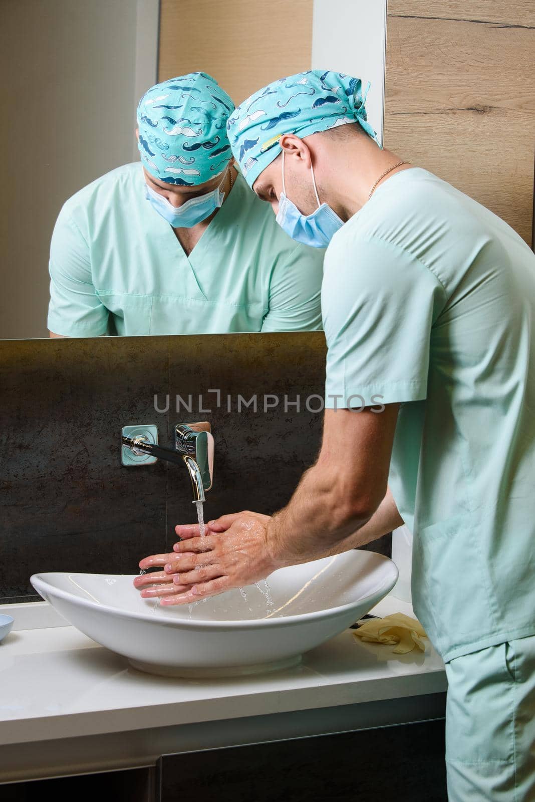 Medical student surgeon cleans his hands with antiseptic. wash hands with soap often under water to stop pandemic of coronavirus covid 19