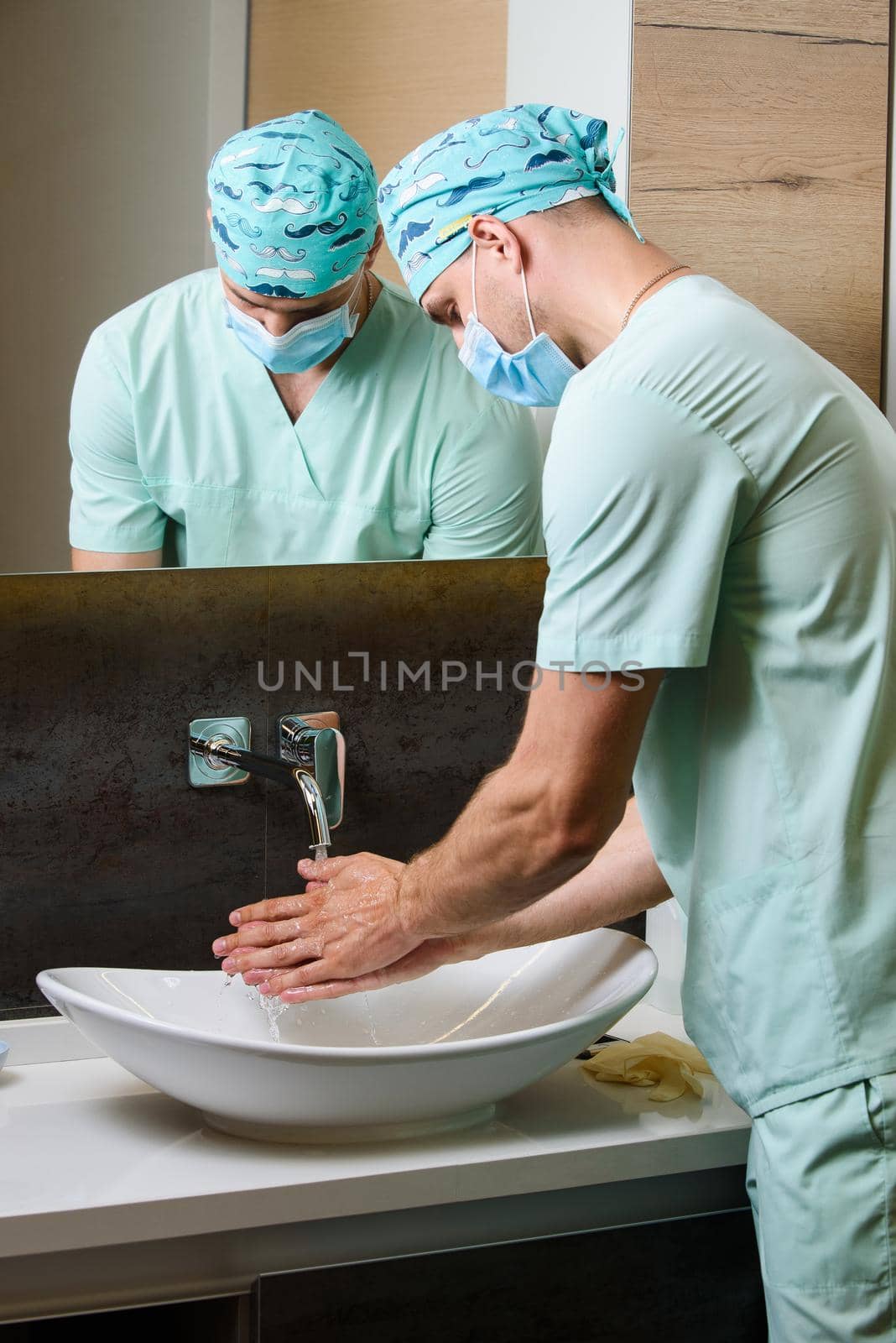 Medical student is washing his hands under running water. Hygiene for doctors. Good method to stop pandemic of coronavirus covid-19
