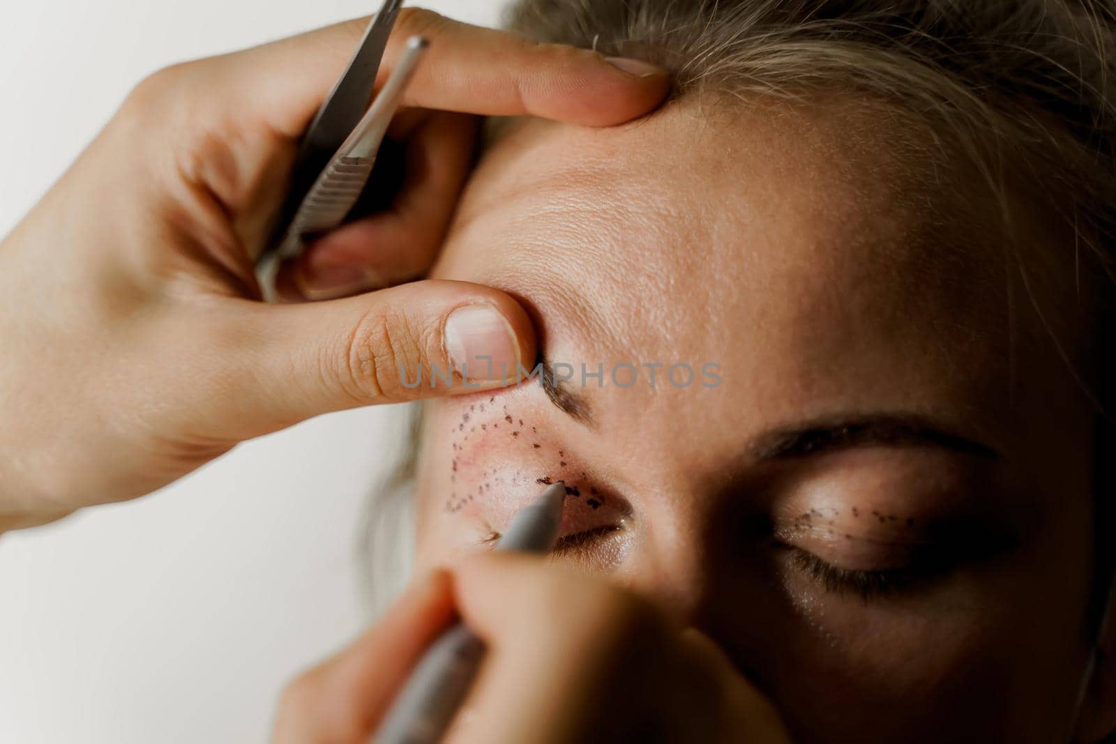 Blepharoplasty markup close-up on the face before the plastic surgery operation for modifying the eye region of the face in medical clinic. 2 doctors do plastic cosmetic operation