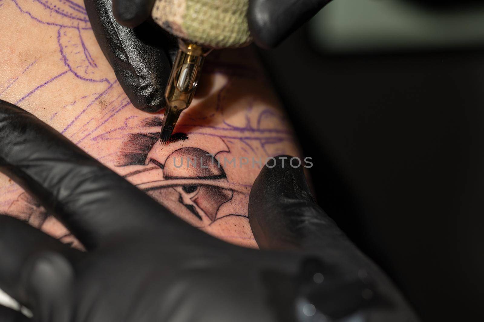 Close up macro view of tattooing process. Master makes contouring lines with his handmade professional liner machine. by HERRAEZ