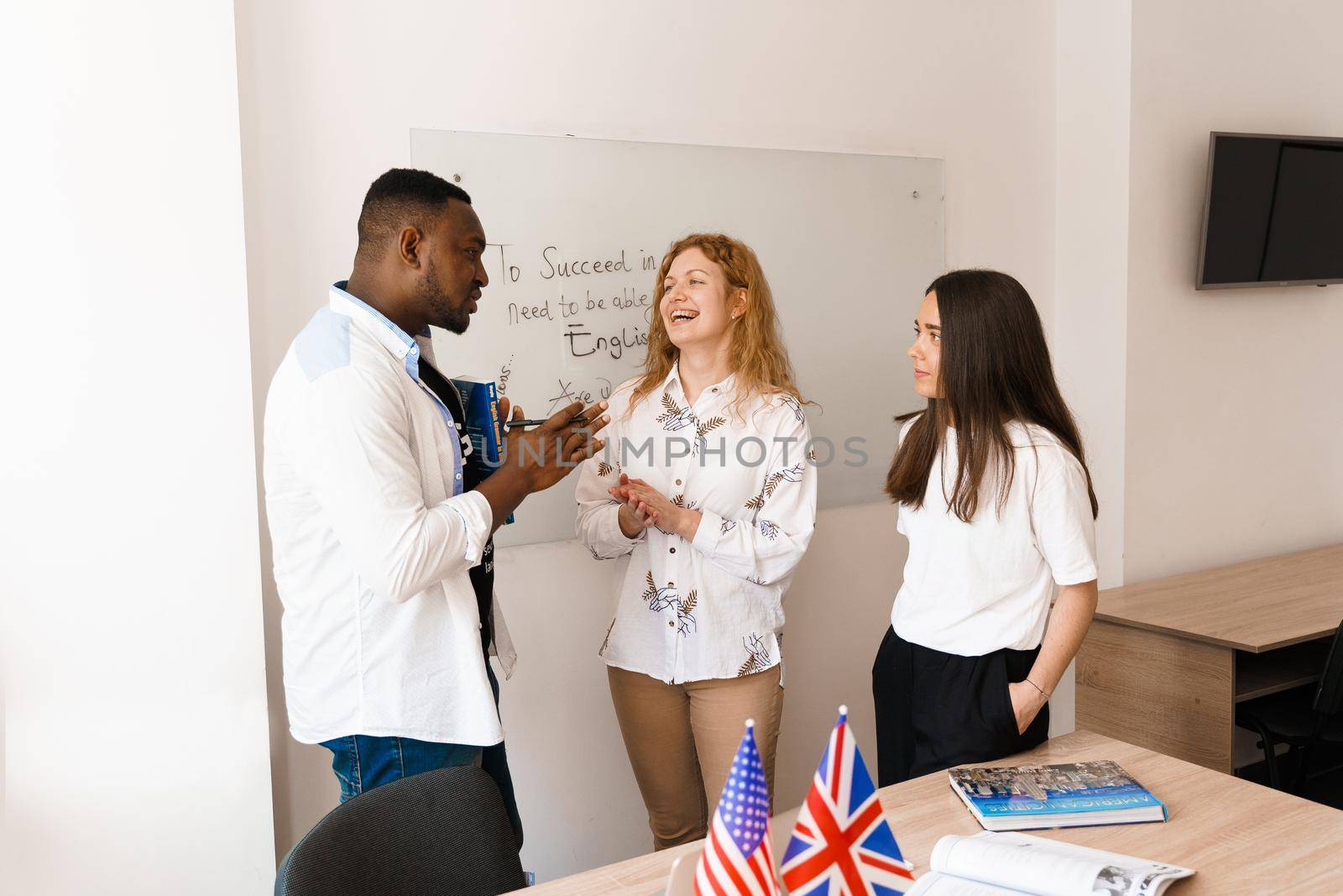 Multiethnic students and teacher study foreign languages together in class. Studing with laptop. Black handsome student study with white people together.