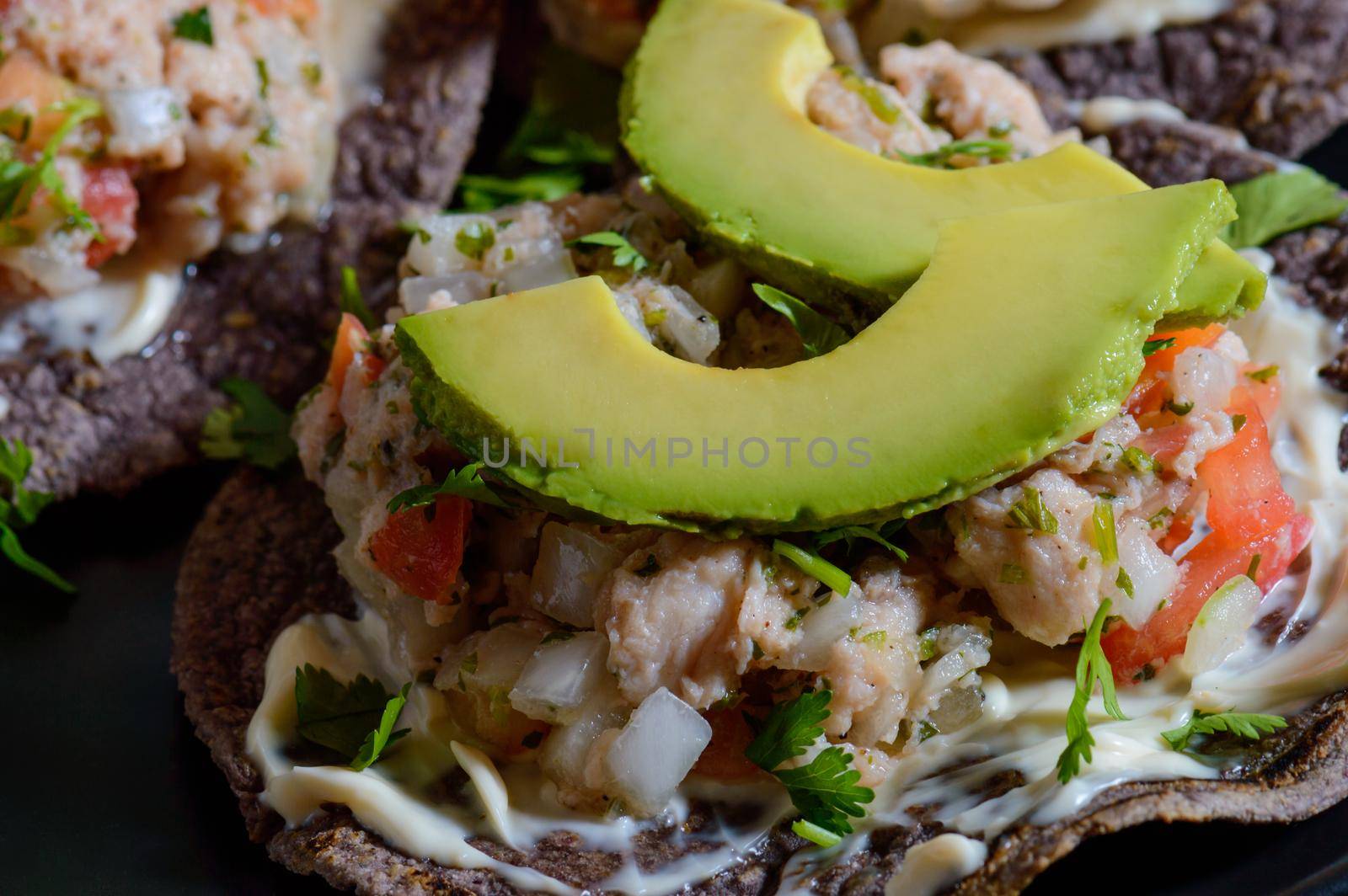 Fish ceviche on blue corn tostadas. Mexican food. Seviche made with tilapia, white fish, onion, tomato, cilantro served on tostadas with mayonnaise
